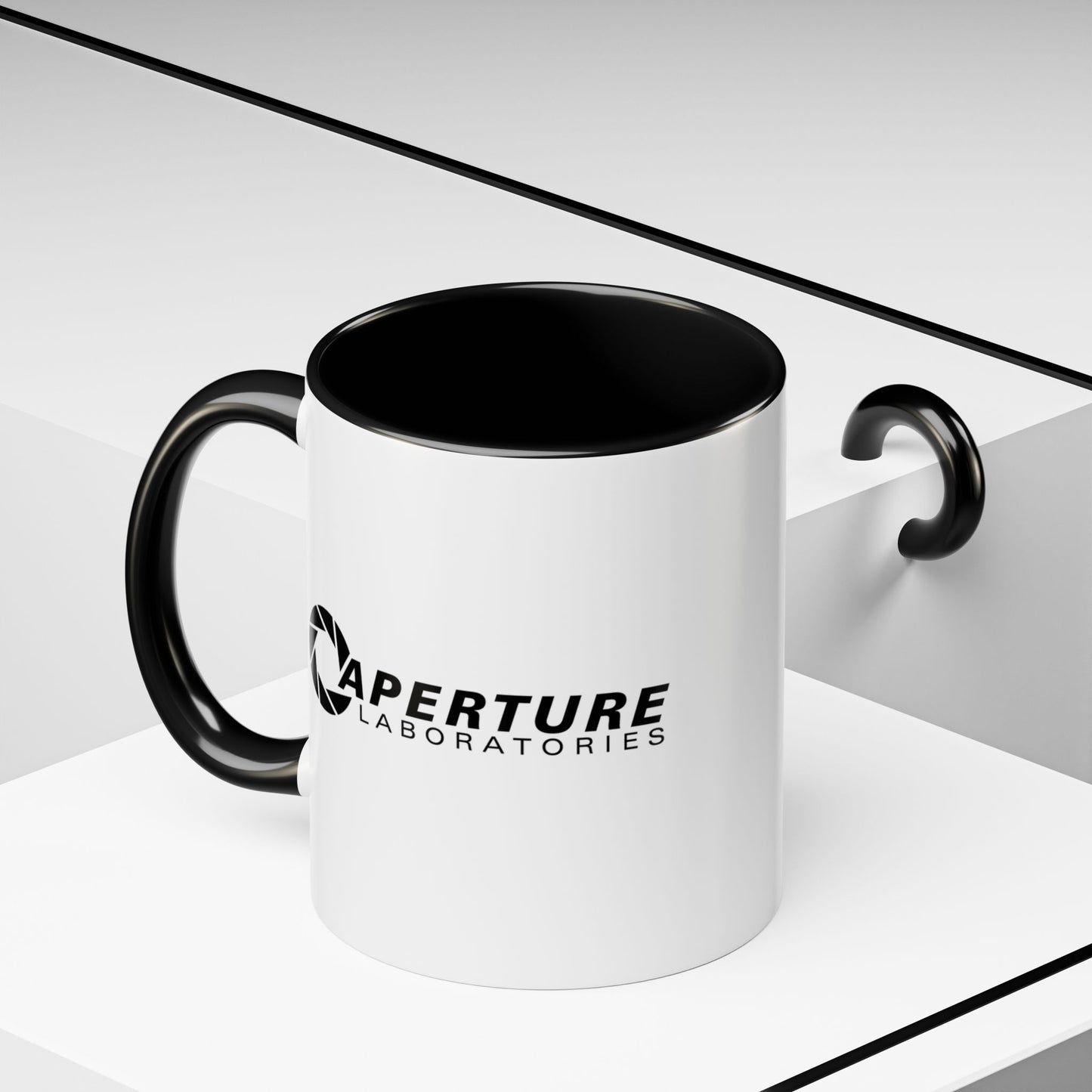 Front angled view of a 11 oz white Ceramic Accent Mug with the black Aperture Laboratories logo from the video game Portal on both sides. Handle and interior are colored black.