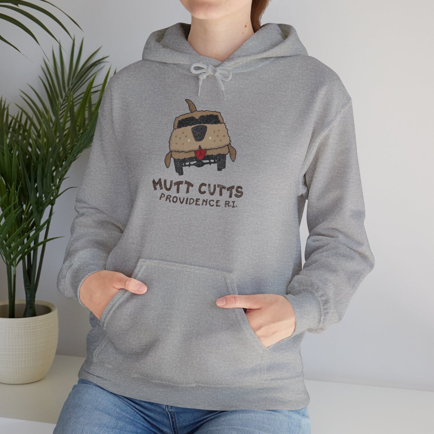 Female model wearing a sport heather grey colored soft Unisex Hoodie Heavy Blend Hooded Sweatshirt featuring a Mutt Cutts logo graphic inspired by the movie Dumb and Dumber, illustrated by ScriptedBrand in a vintage distressed style.