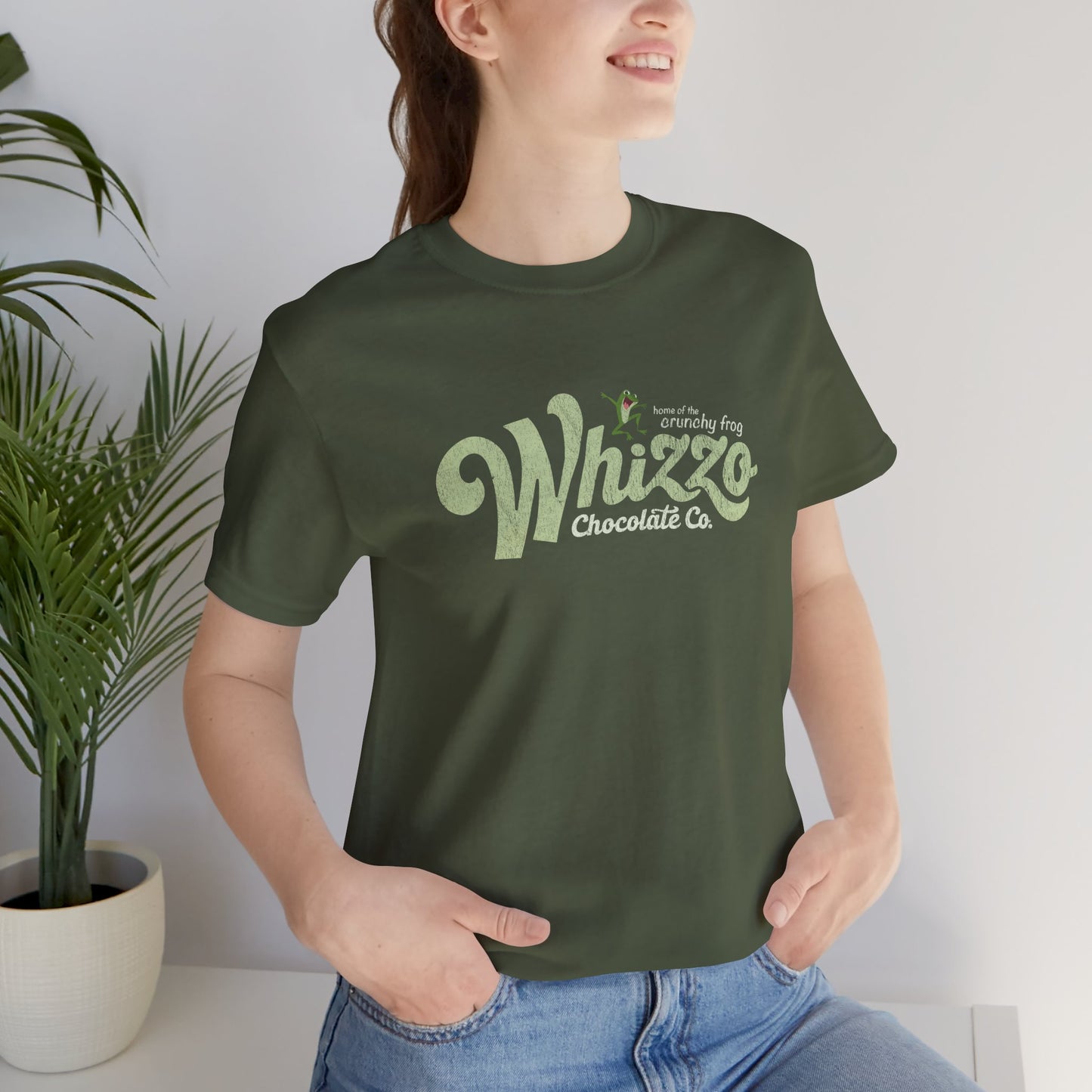 Female wearing t-shirt with vintage Whizzo Chocolate Co. logo, inspired by Monty Python, featuring “home of the crunchy frog” graphic.