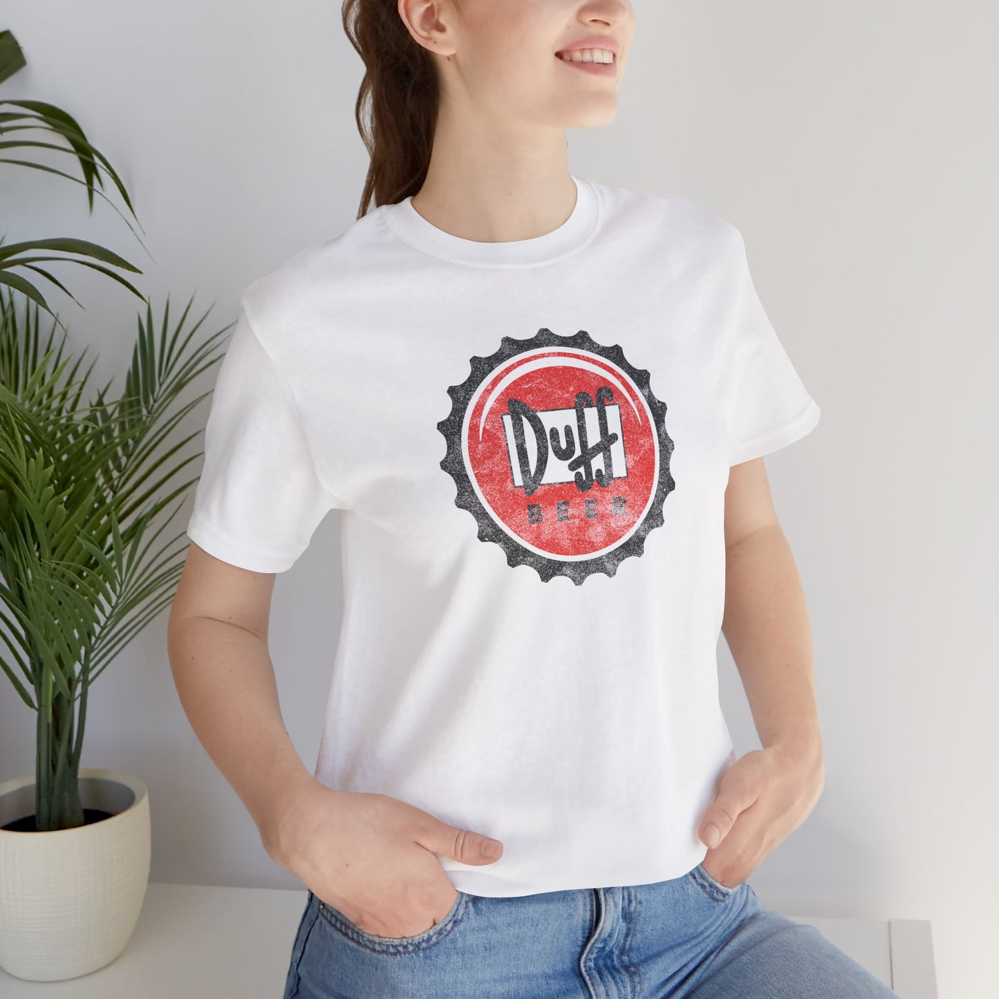 Woman wearing white t-shirt featuring the Duff Beer bottle cap logo from the TV Show The Simpsons in vintage distressed style.