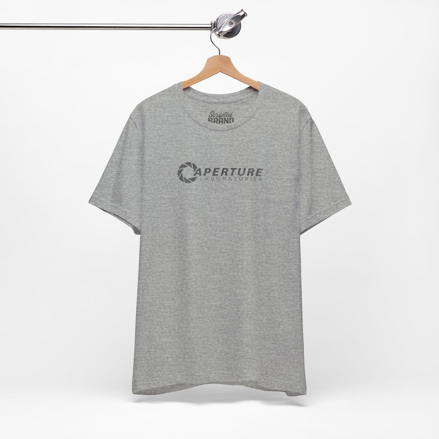 Athletic gray colored soft Bella+Canvas t-shirt on a hanger with the Aperture Laboratories logo from the video game Portal and Portal 2 in a vintage ink-stamped distressed style.