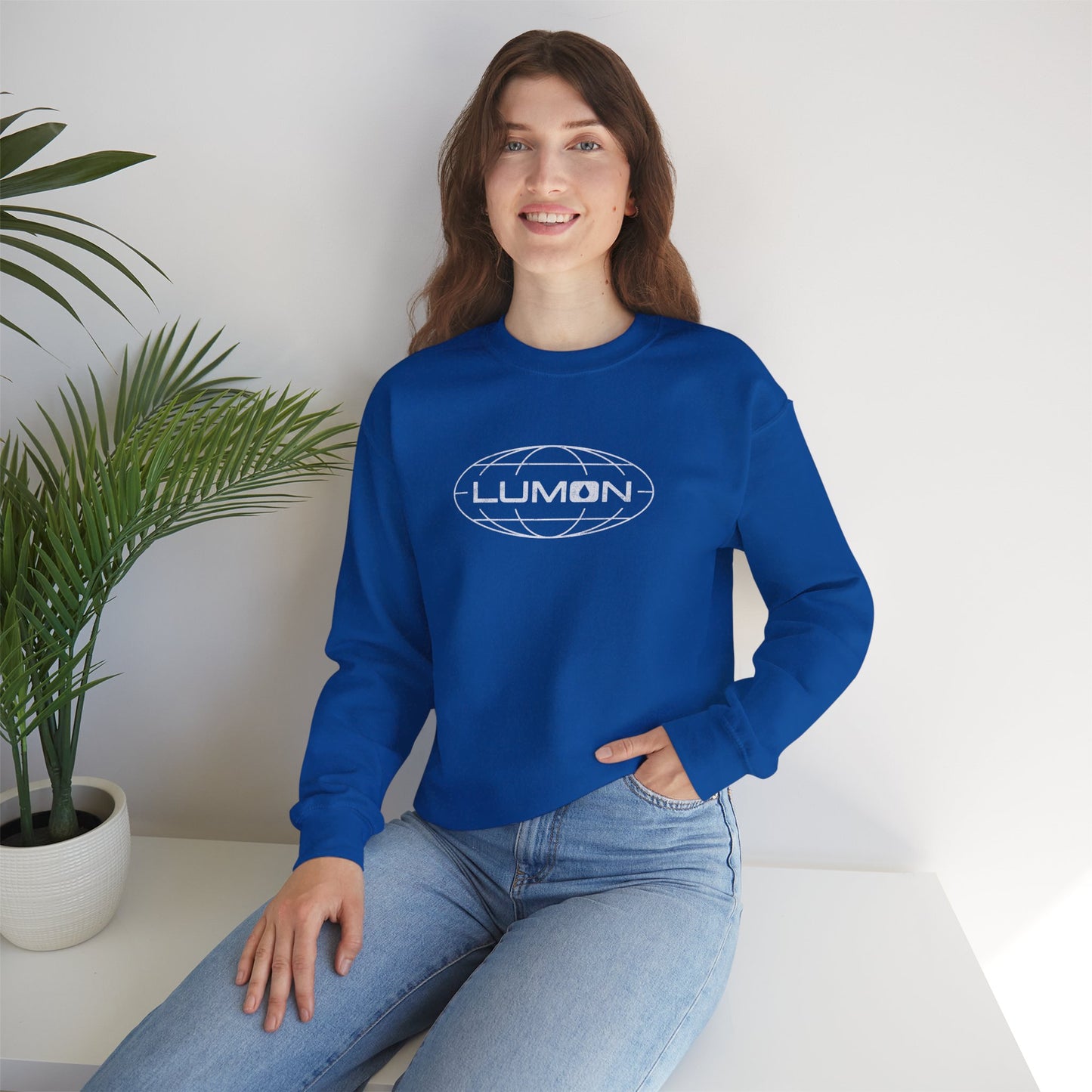 Female model wearing a royal blue Soft Gildan 18000 crew neck sweatshirt featuring the Lumon Industries logo from the Apple TV show Severance in a vintage distressed style.