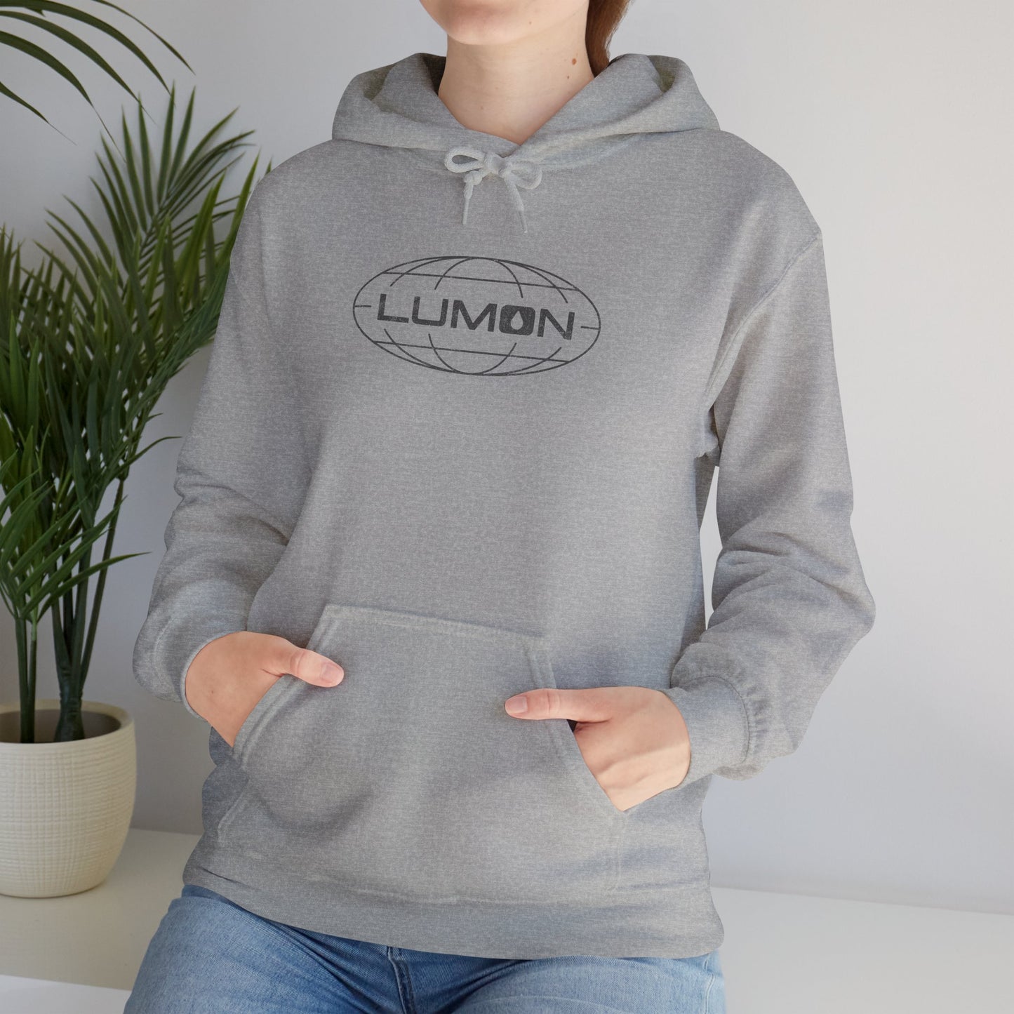 Woman model wearing a Sport Heather Gray Blue colored Soft Unisex Heavy Blend Hooded Sweatshirt featuring the fictional Lumon Industries logo from the Apple TV show Severance.