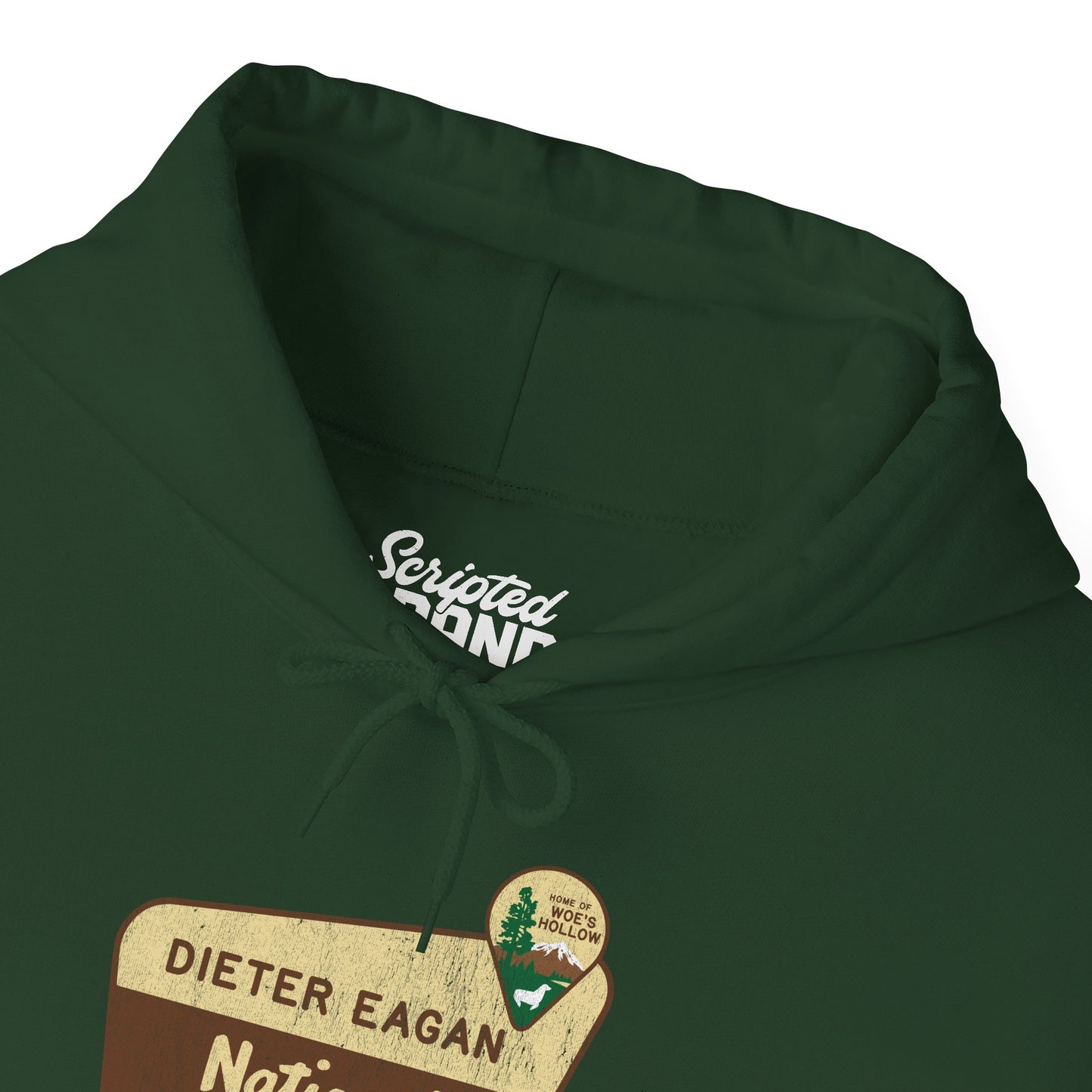 Zoomed in Forest green colored Soft Unisex Hoodie Heavy Blend Hooded Sweatshirt featuring the logo graphic of the Dieter Eagan National Forest inspired by the TV show Severance in a vintage distressed ink-stamped worn-in style.