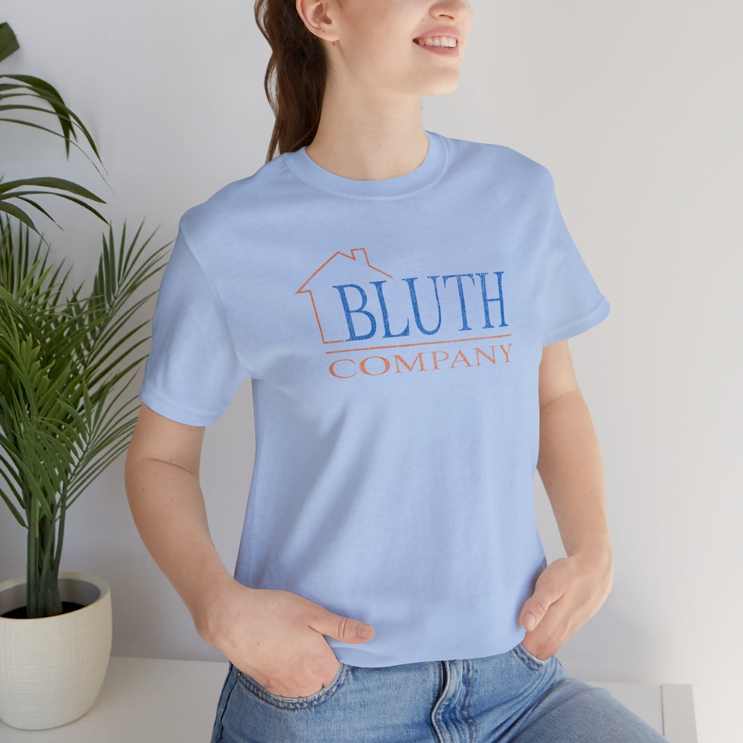 female wearing baby blue Bella+Canvas t-shirt featuring a vintage Bluth Company logo inspired by the TV show Arrested Development