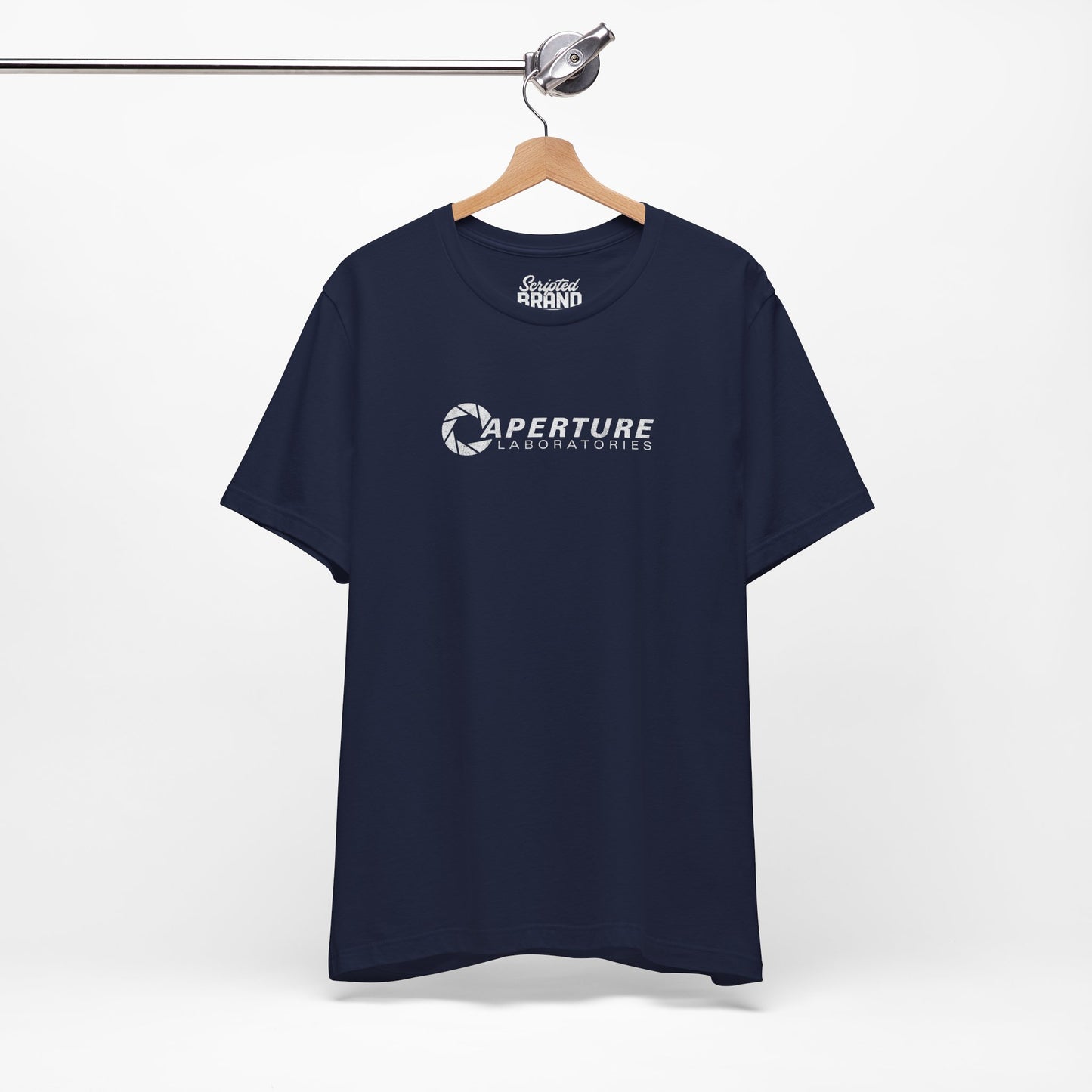 Navy blue colored soft Bella+Canvas t-shirt on a hanger with the Aperture Laboratories logo from the video game Portal and Portal 2 in a vintage ink-stamped distressed style.
