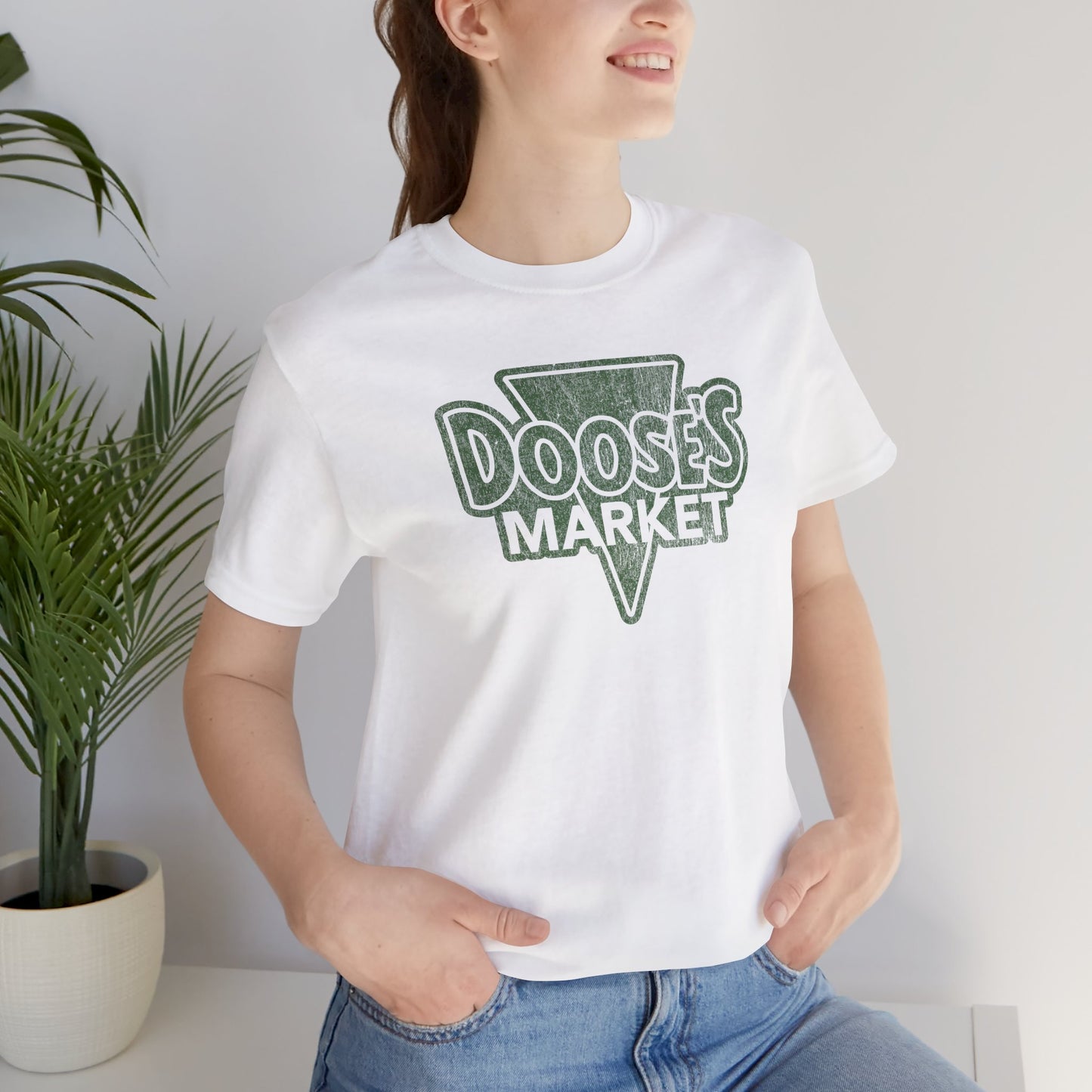 female wearing white Bella+Canvas t-shirt with a vintage-style Doose’s Market logo graphic, inspired by Gilmore Girls