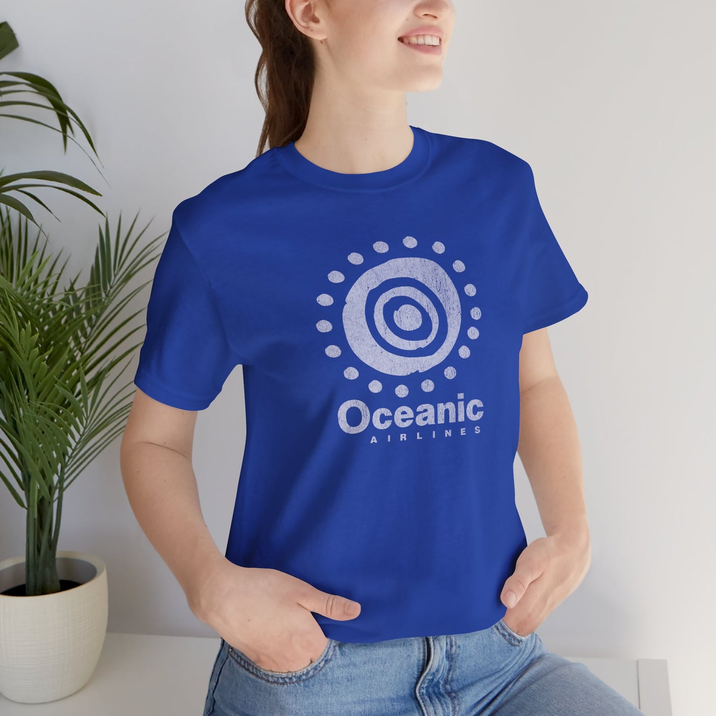Woman wearing blue t-shirt featuring the Oceanic Airlines logo graphic from the TV show LOST in a vintage distressed style.