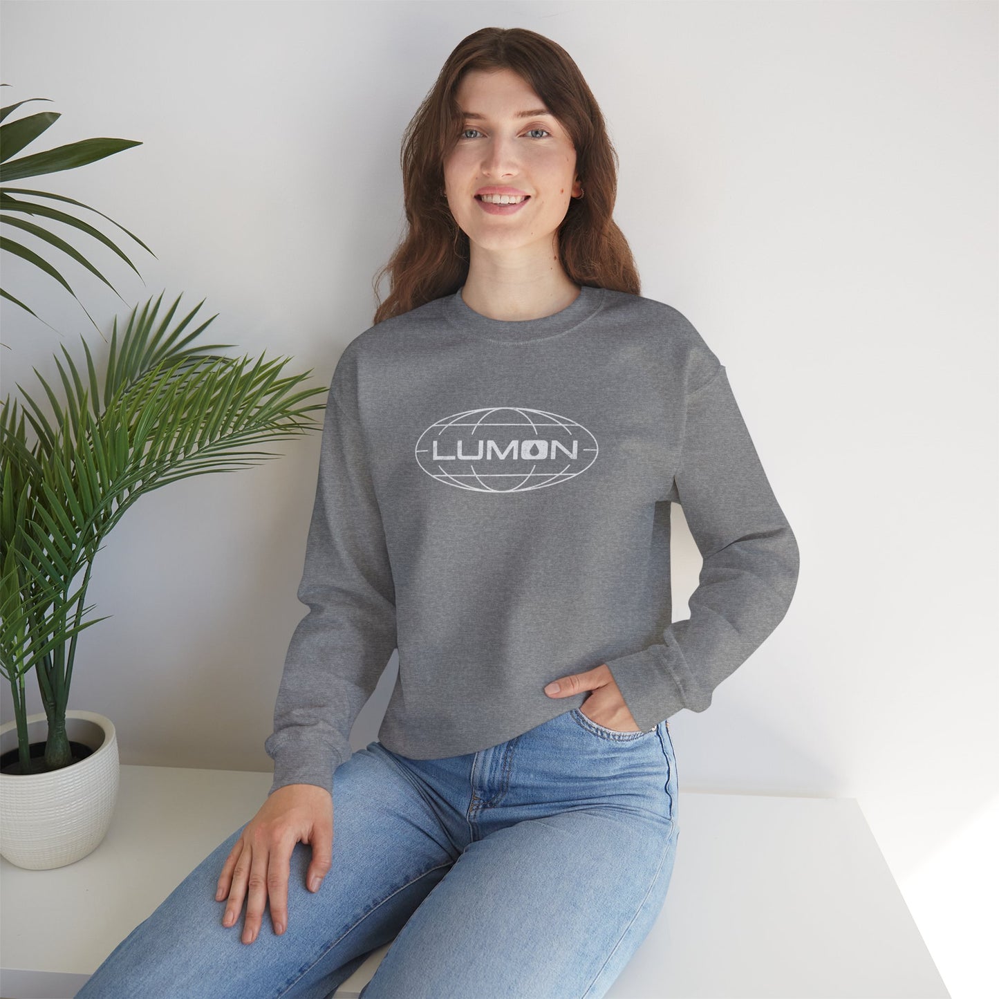 Female model wearing a heather gray Soft Gildan 18000 crew neck sweatshirt featuring the Lumon Industries logo from the Apple TV show Severance in a vintage distressed style.