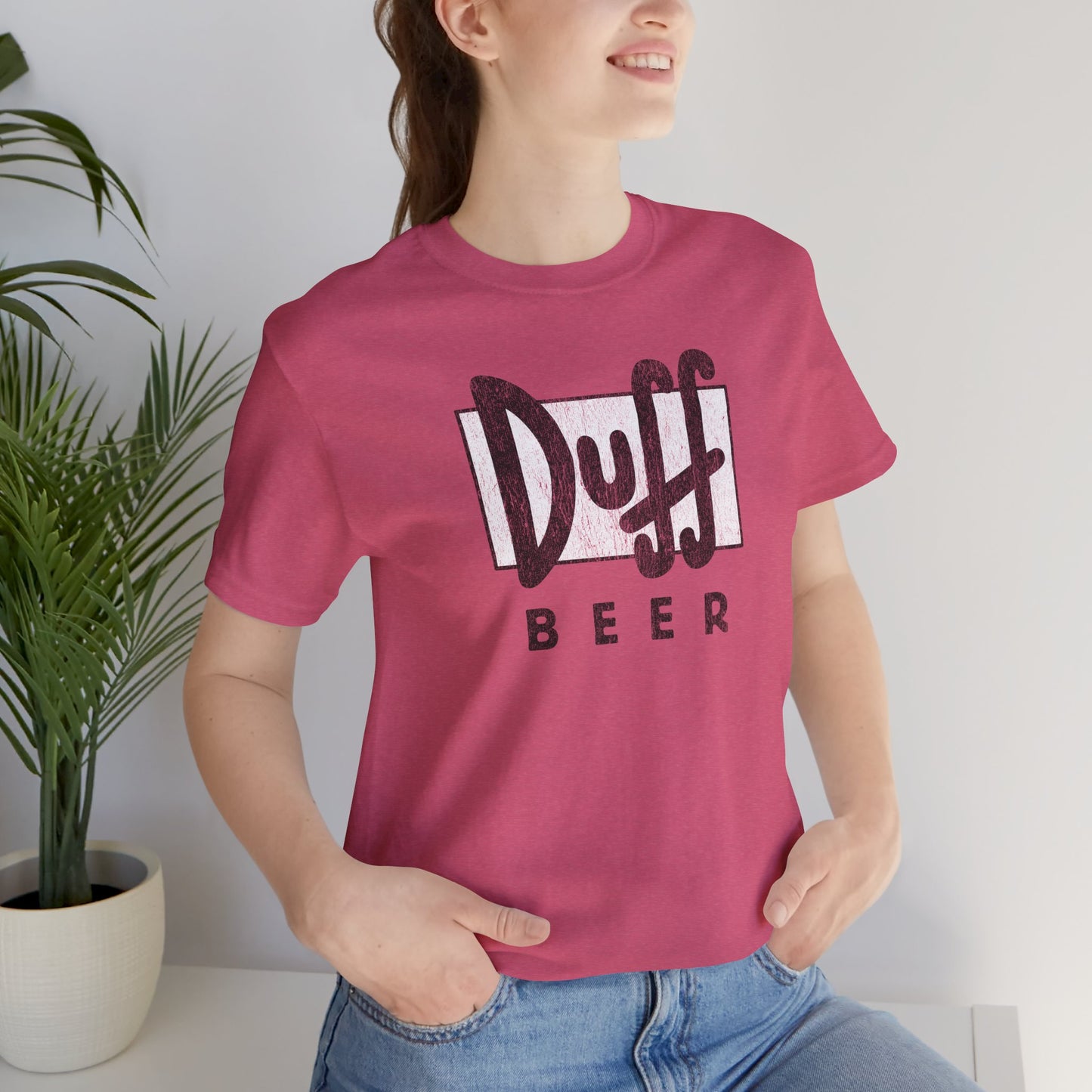 Woman wearing Heather Raspberry t-shirt featuring the Duff Beer logo from the TV Show The Simpsons in vintage distressed style.