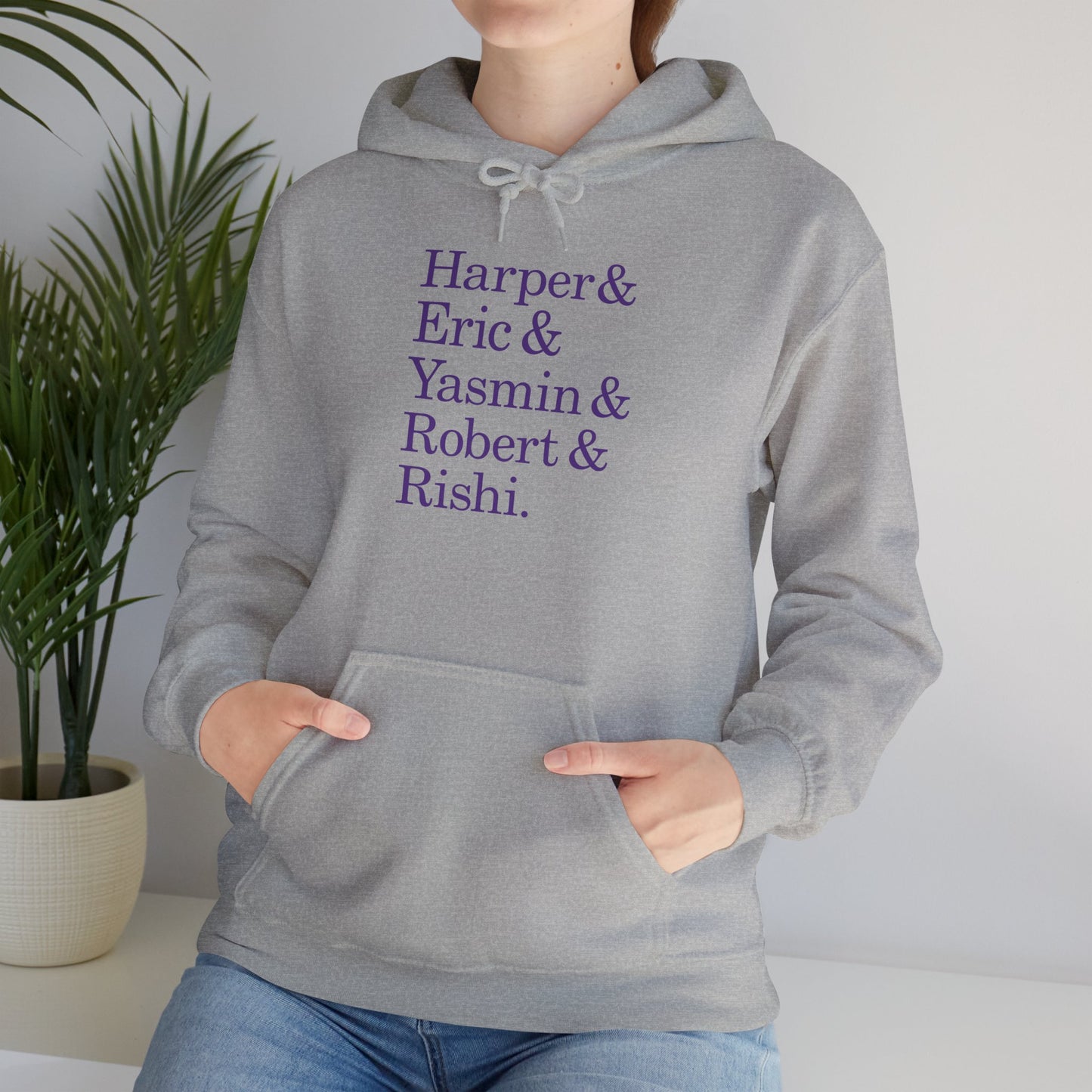 Woman wearing sport heather gray hoodie with names Harper, Eric, Yasmin, Robert & Rishi in Pierpoint & Co. font, inspired by TV show Industry.