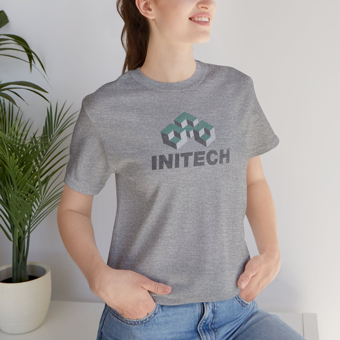 Female model wearing an athletic heather grey colored soft Bella+Canvas 3001 short-sleeve t-shirt featuring the Initech logo from the movie Office Space in a vintage distressed style, sold by ScriptedBrand.