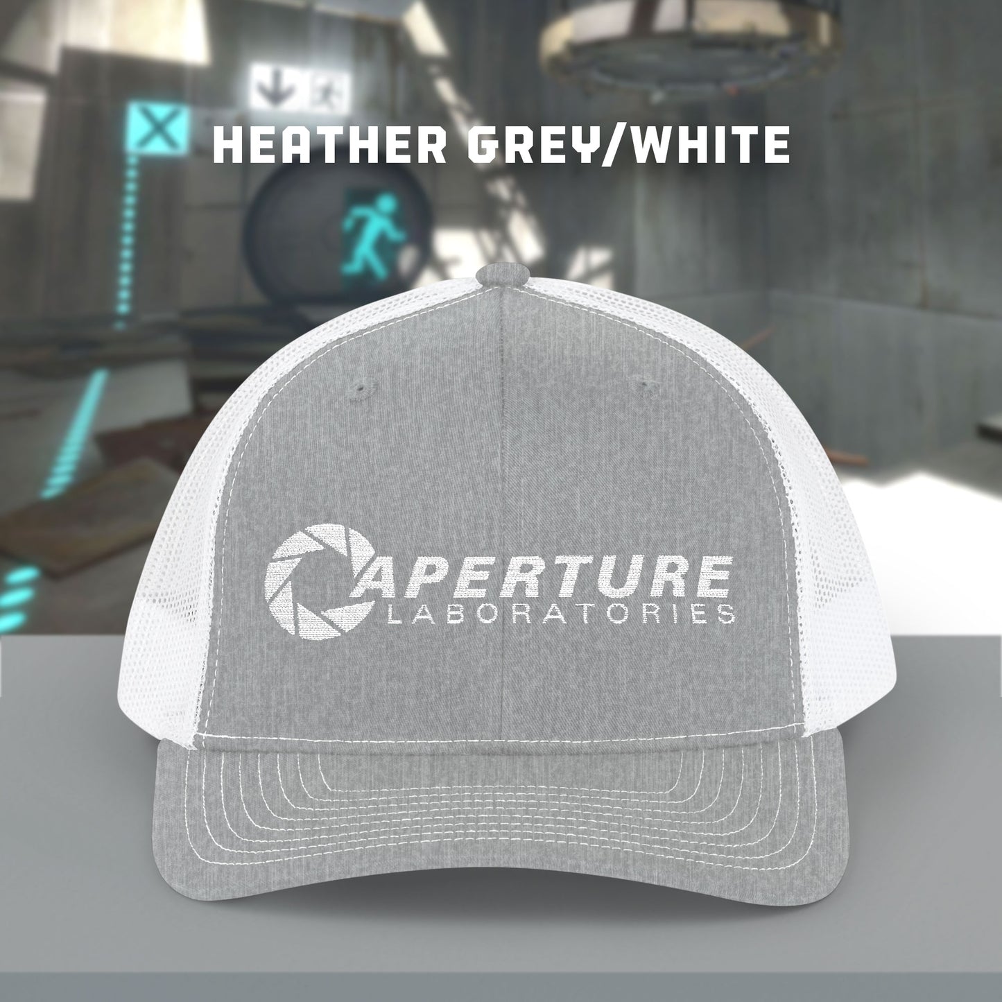 Front view of a heather grey/white colored Richardson 112 Snapback Trucker Cap featuring the embroidered logo of the fictional company Aperture Laboratories from the video game Portal and Portal 2, sold by ScriptedBrand.