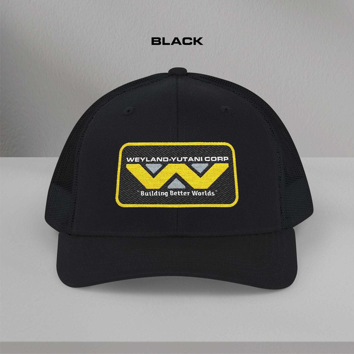 Front view of black Embroidered Snapback Trucker Cap with logo of Weyland-Yutani from the Alien movie franchise.