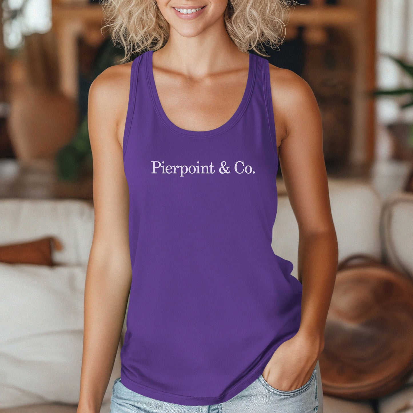 Female model wearing a purple colored Women's Racerback Tank Top Shirt featuring the Pierpoint & Co logo from the HBO TV show Industry, sold by ScriptedBrand.