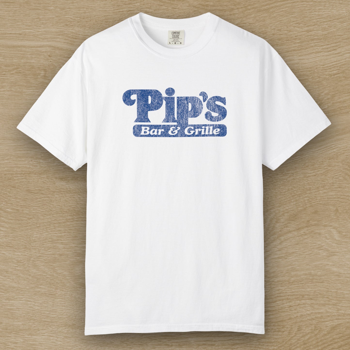 Vintage-style Pip’s Bar & Grill t-shirt from Severance on Comfort Colors 1717 in the color white, blue distressed logo.