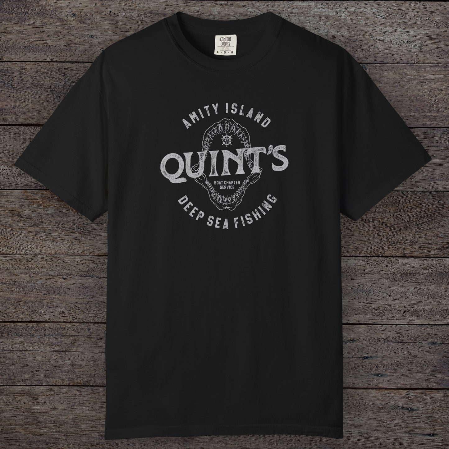 Black Comfort Colors t-shirt with vintage Quint’s Deep Sea Fishing logo from Jaws, featuring shark graphic, distressed style.