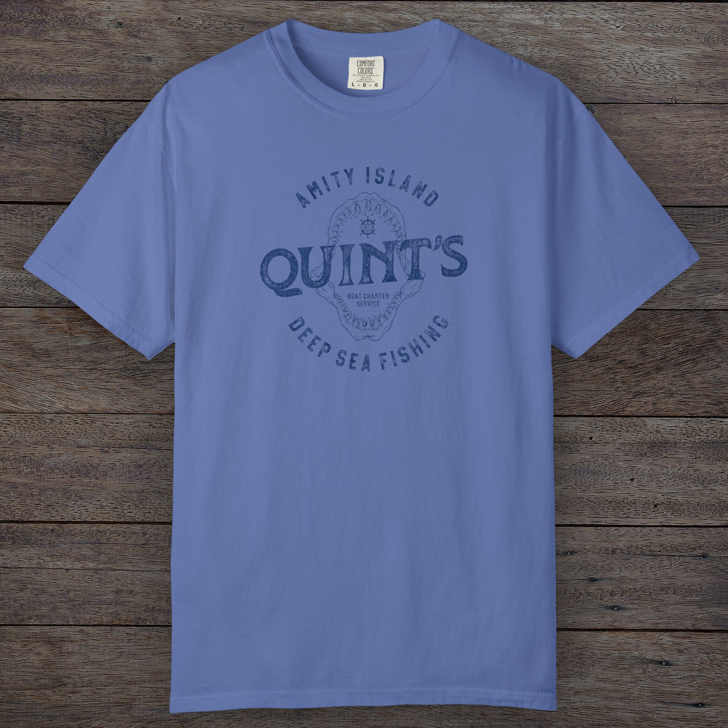 Mystic Blue Comfort Colors t-shirt with vintage Quint’s Deep Sea Fishing logo from Jaws, featuring shark graphic, distressed style.