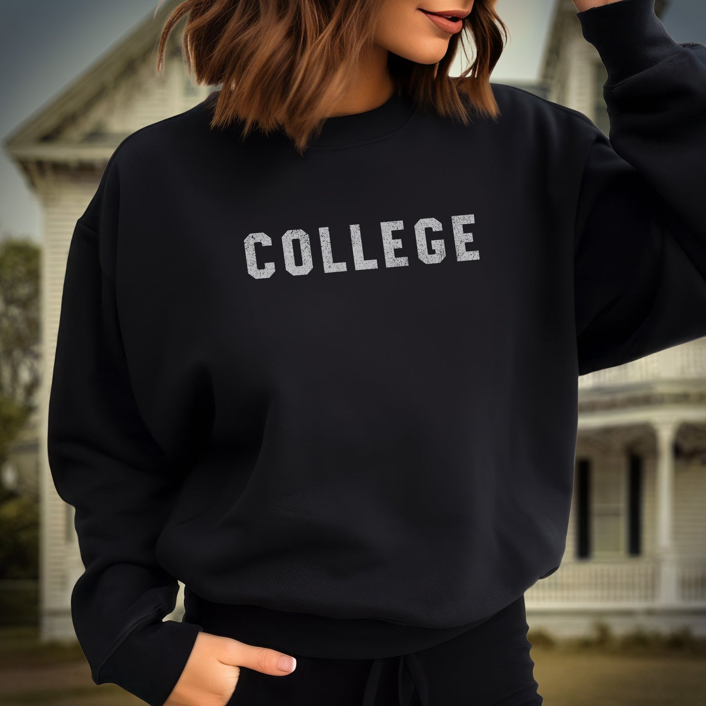 Female model wearing a black colored soft unisex Gildan 18000 sweatshirt with the word COLLEGE that John Belushi wore in the movie Animal House, in a vintage distressed ink-stamped worn-in style.