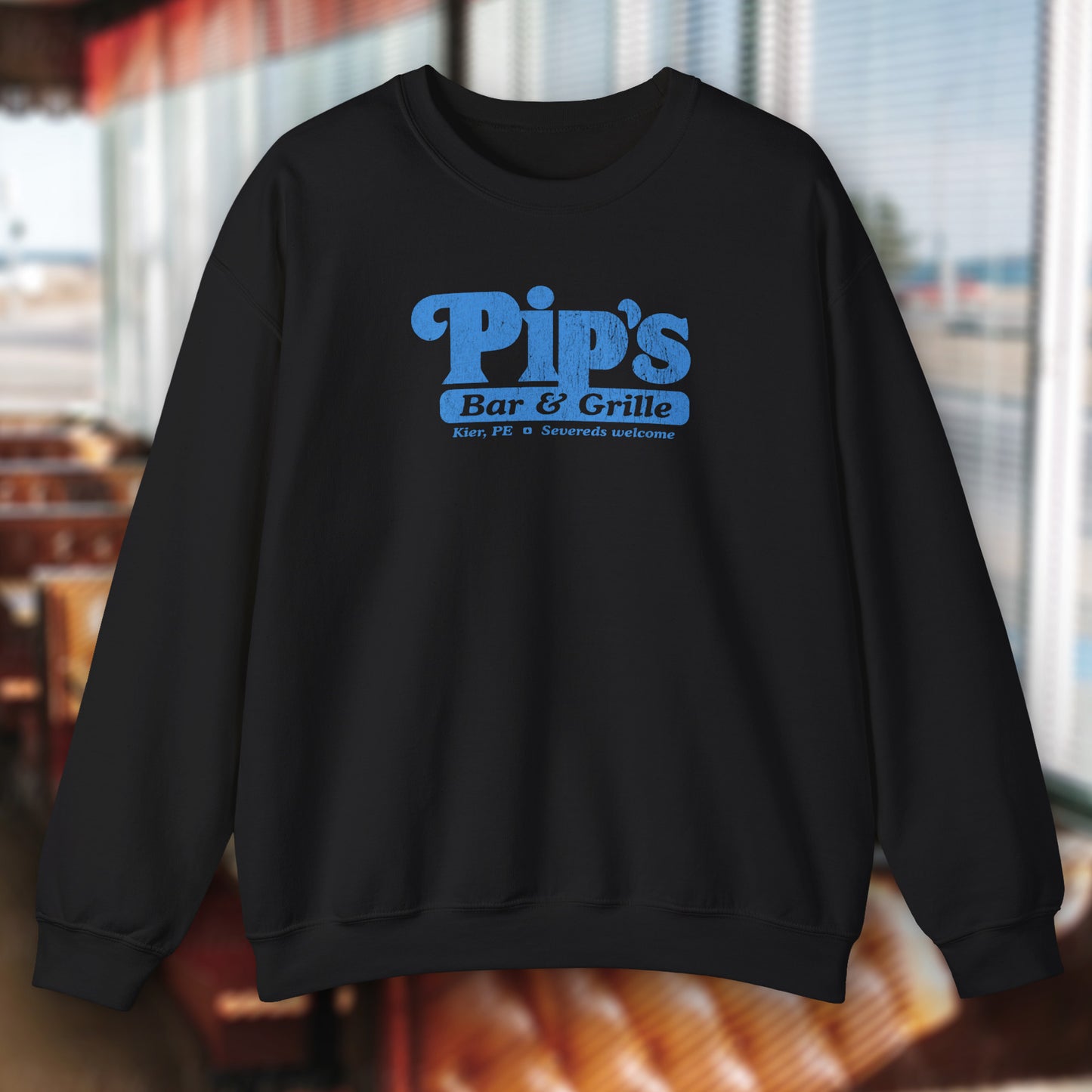 Black Soft Gildan 18000 sweatshirt featuring the Pips Bar and Grill logo Severeds Welcome from the TV show Severance in a vintage distressed ink-stamped worn-in style.