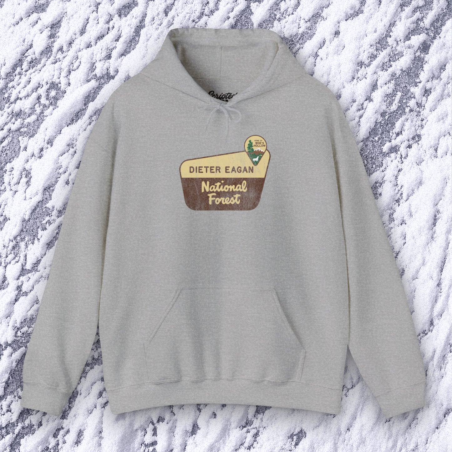 Mockup of a Sport Heather Gray colored Soft Unisex Hoodie Heavy Blend Hooded Sweatshirt featuring the logo graphic of the Dieter Eagan National Forest inspired by the TV show Severance in a vintage distressed ink-stamped worn-in style.