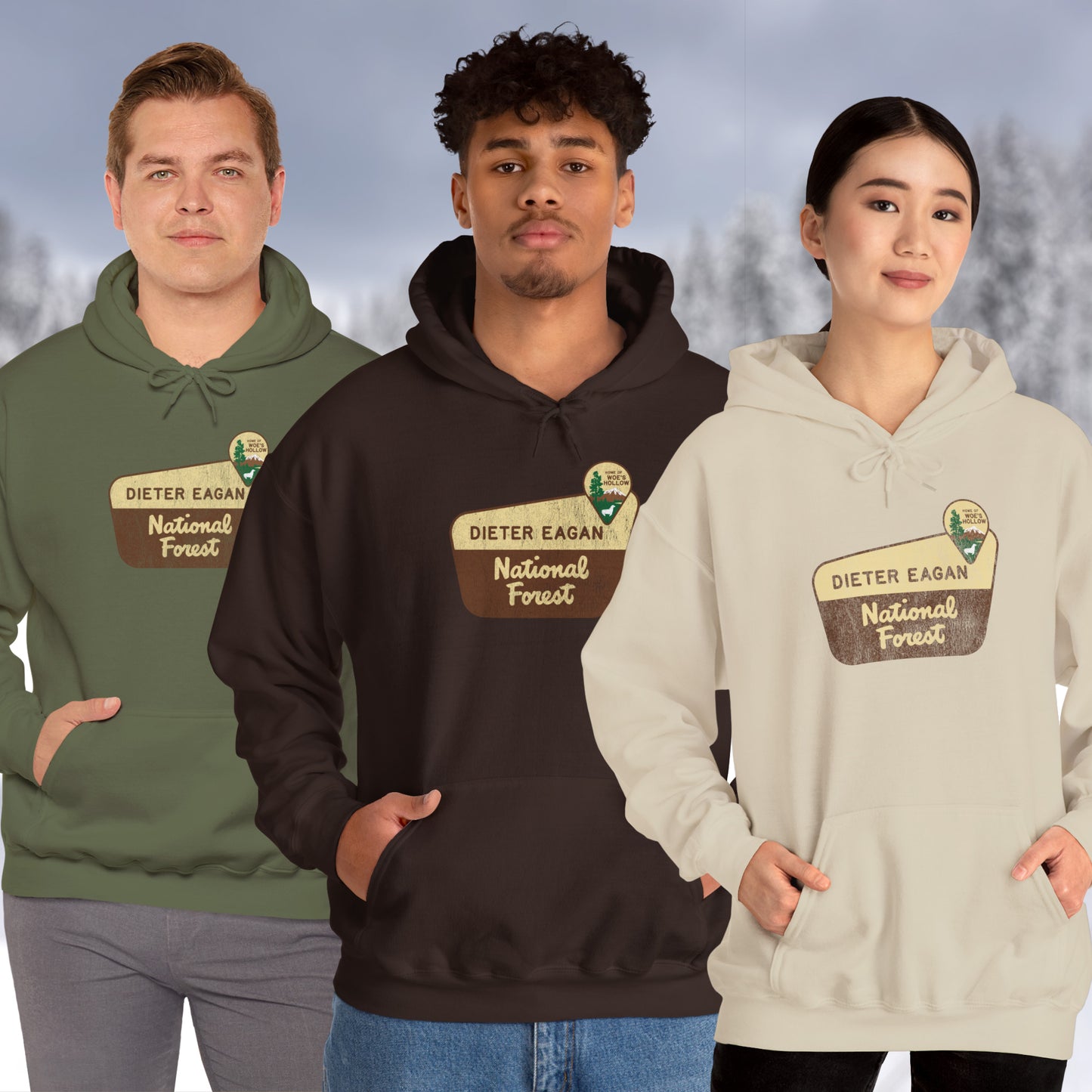3 models wearing Soft Unisex Hoodie Heavy Blend Hooded Sweatshirts featuring the logo graphic of the Dieter Eagan National Forest inspired by the TV show Severance in a vintage distressed ink-stamped worn-in style.