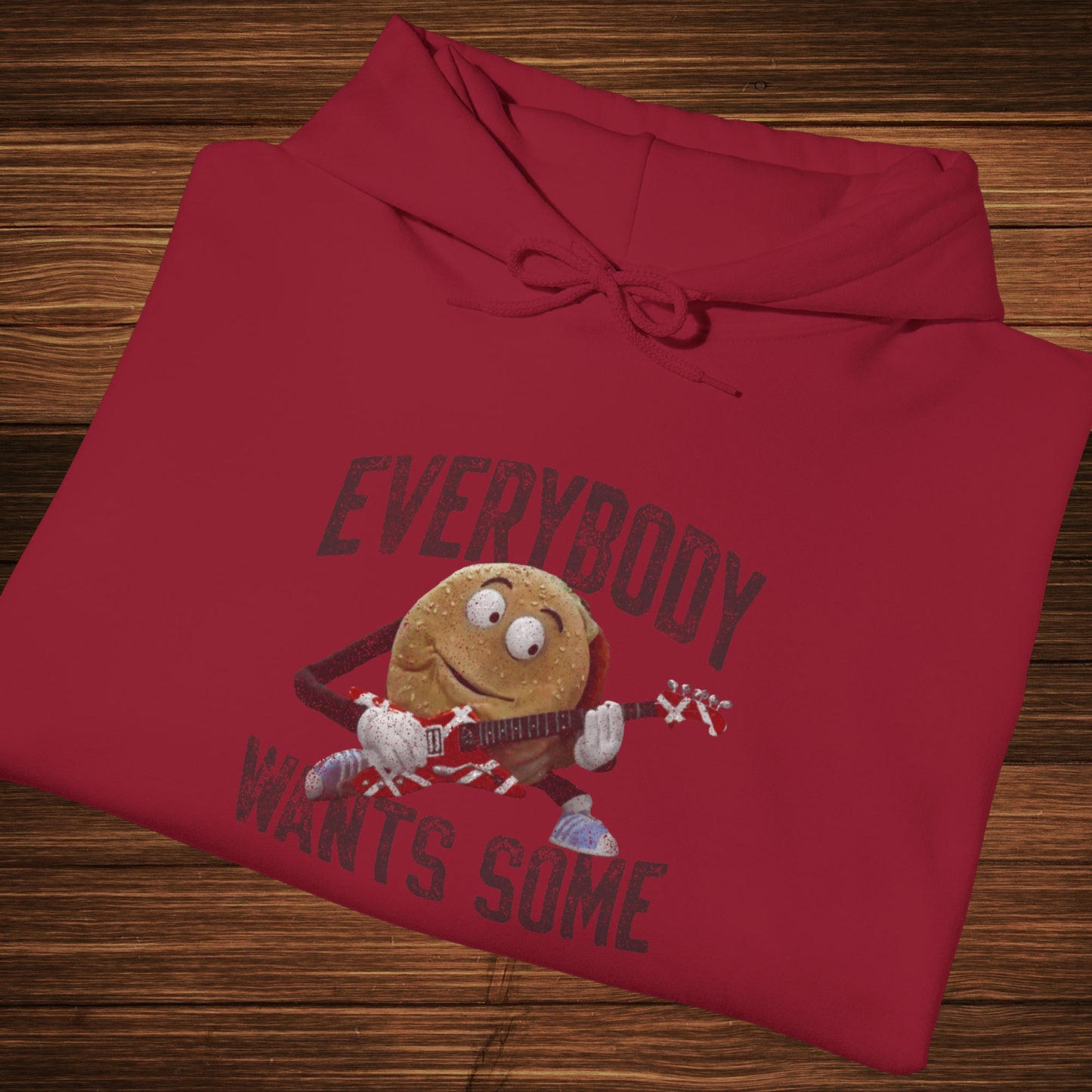 Folded cardinal red colored soft Unisex Hoodie Heavy Blend Hooded Sweatshirt featuring the phrase EVERYBODY WANTS SOME with a graphic of the Van Halen singing hamburger playing guitar from the movie Better Off Dead, designed by ScriptedBrand in a vintage distressed style.