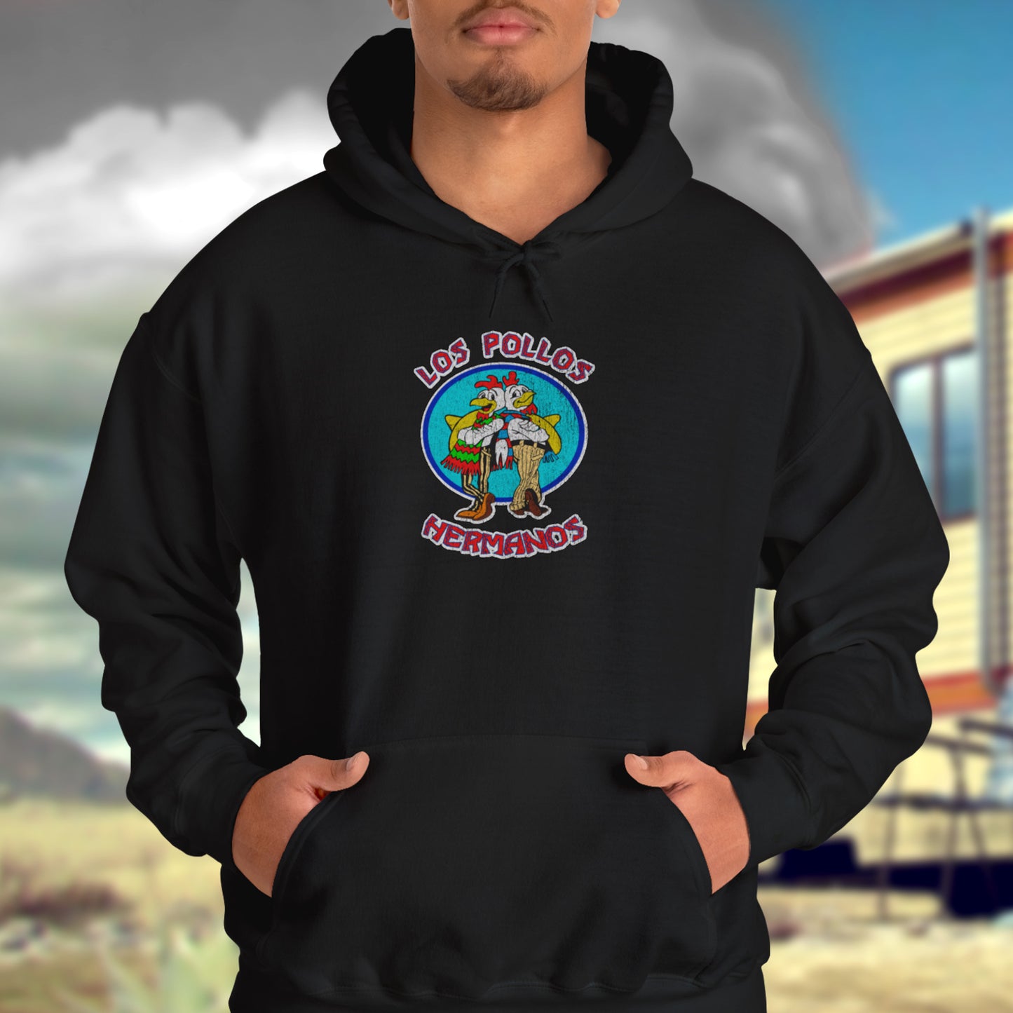 Male model wearing black Soft Unisex Hoodie Heavy Blend Hooded Sweatshirt featuring the Los Pollos Hermanos logo from the TV show Breaking Bad and Better Call Saul in a vintage distressed style. Logo is printed on both front and back of hoodie.