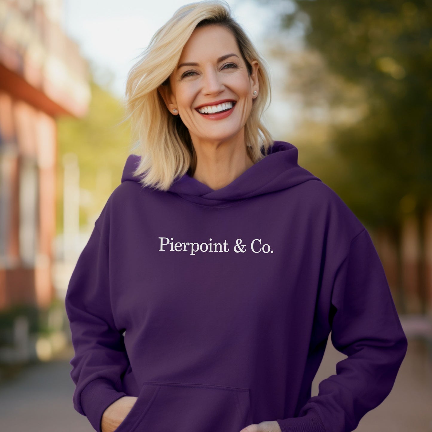 smiling Female model wearing a Purple soft Unisex Hoodie Heavy Blend Hooded Sweatshirt featuring the Pierpoint & Co logo worn by the character Eric Tao in the TV show Industry.