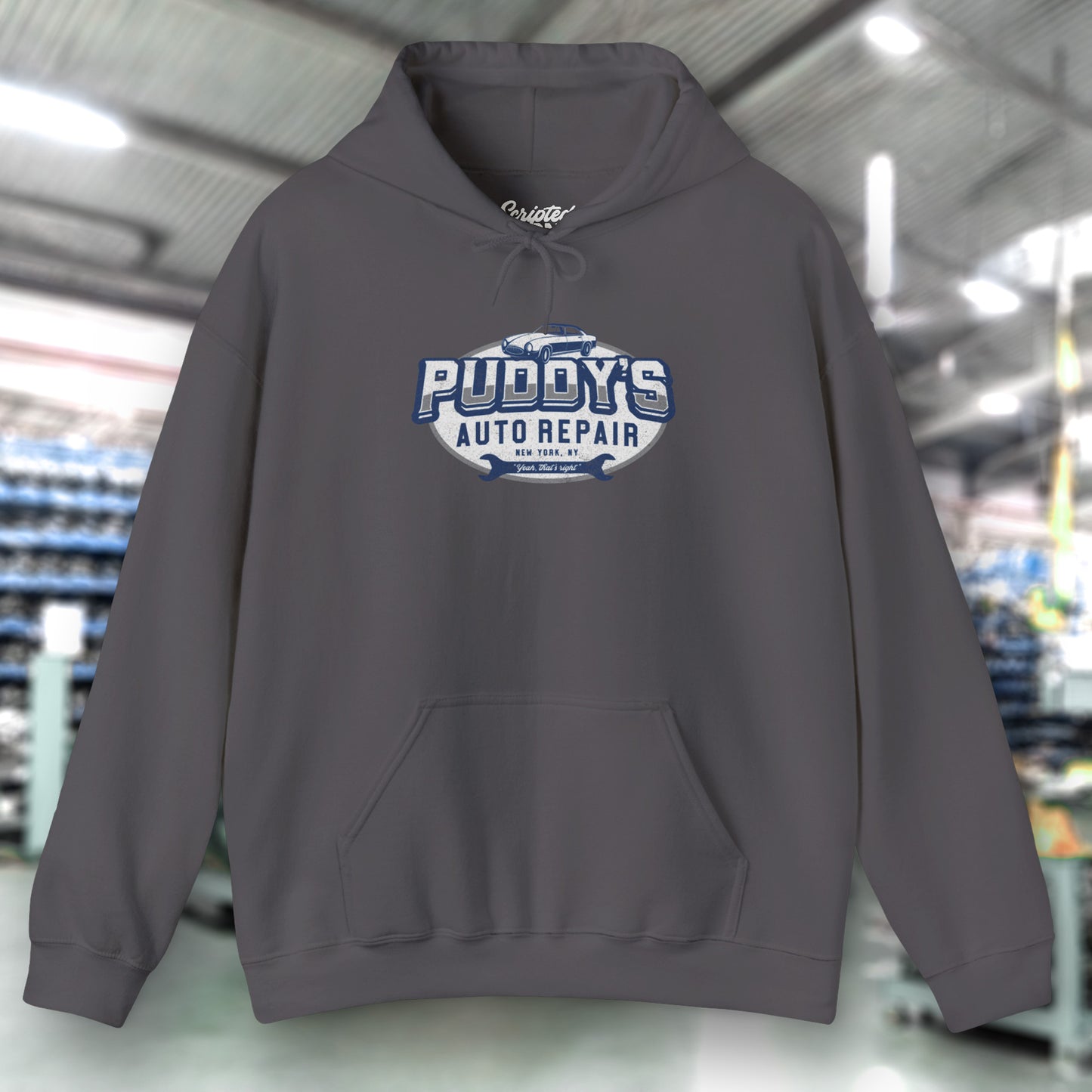 Front view of a charcoal gray soft Unisex Hoodie Heavy Blend Hooded Sweatshirt featuring a Puddy's Auto Repair graphic designed by ScriptedBrand inspired by the TV show Seinfeld in a vintage distressed style.