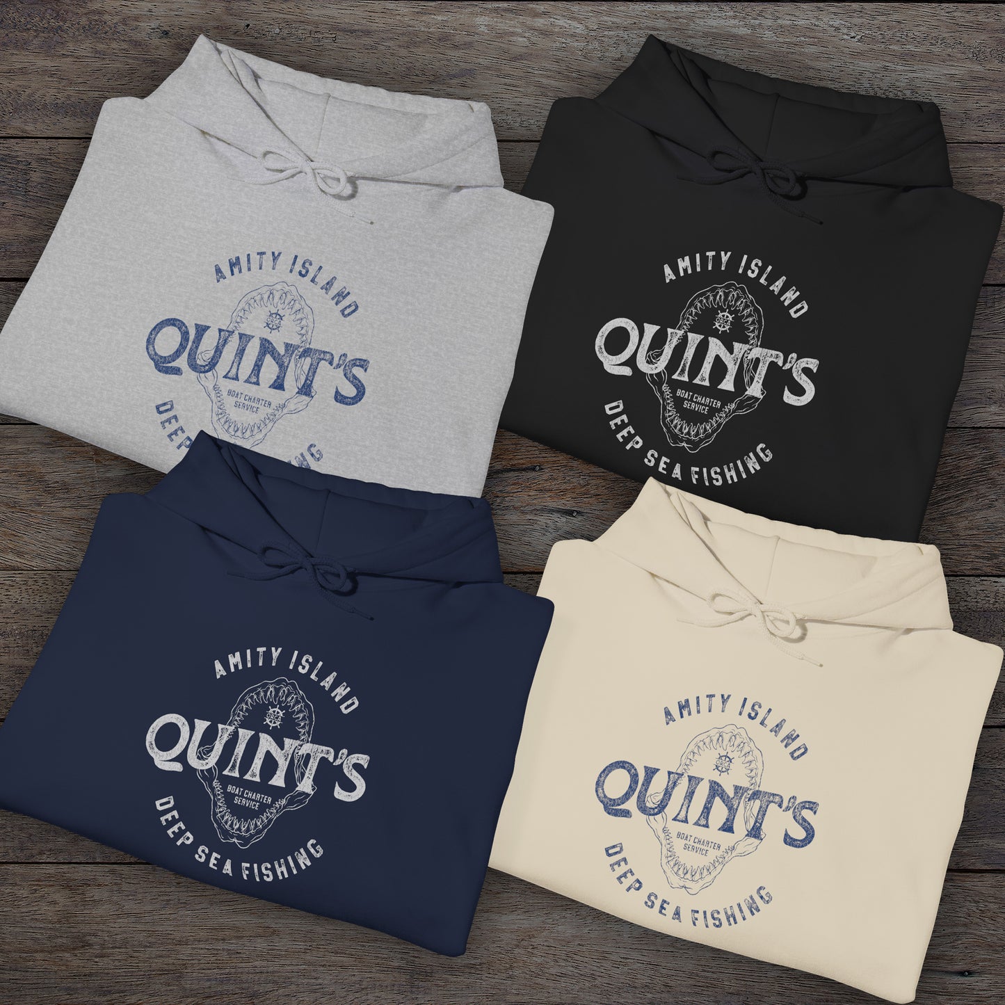 Group of 4 folded Soft Unisex Hoodie Heavy Blend Hooded Sweatshirts featuring a Quint's Deep Sea Fishing Boat Charters logo graphic, designed by ScriptedBrand, and inspired by the movie Jaws in a vintage distressed style.