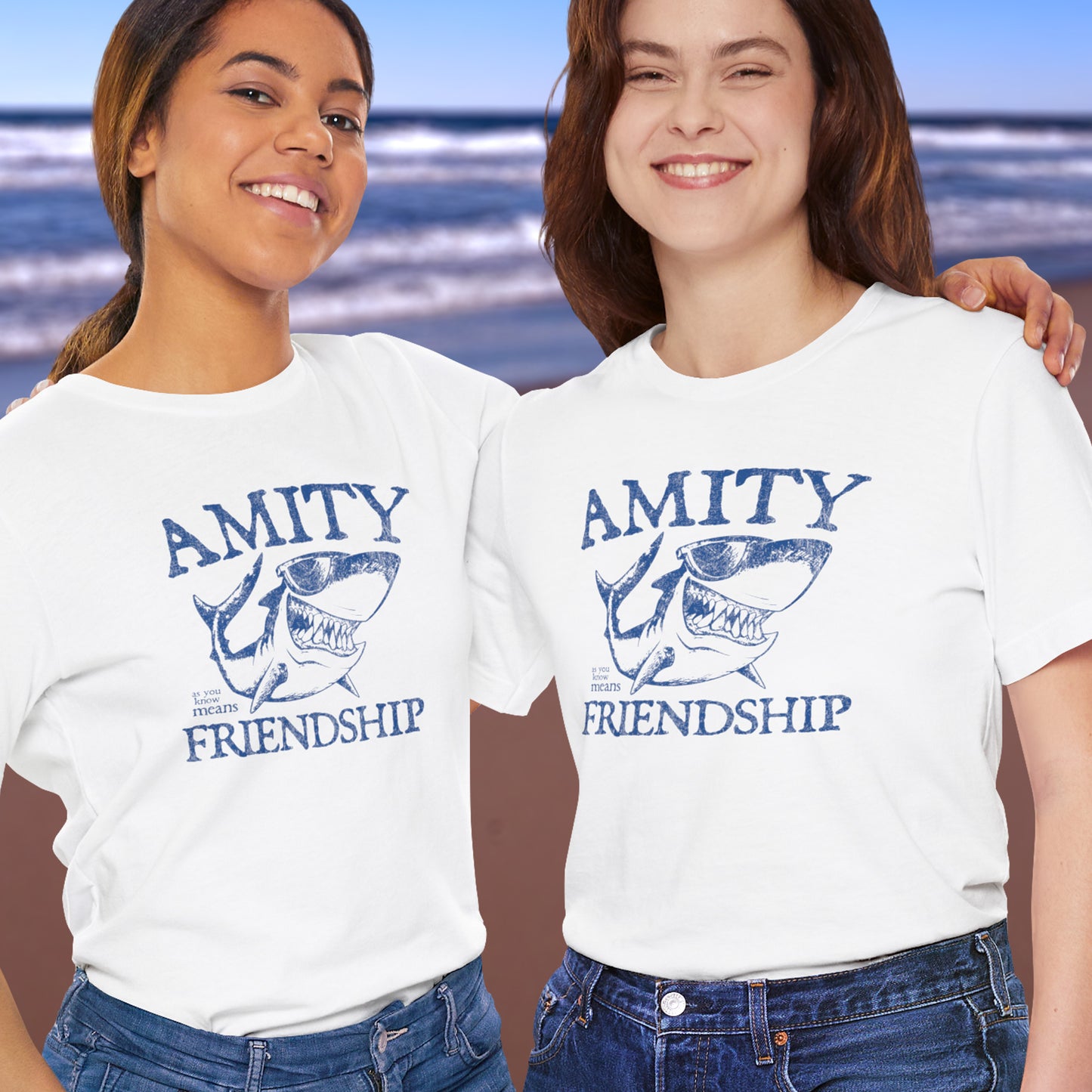 2 Females wearing white Bella+Canvas t-shirts with a vintage-style Amity Island “Friendship” shark graphic inspired by the movie Jaws