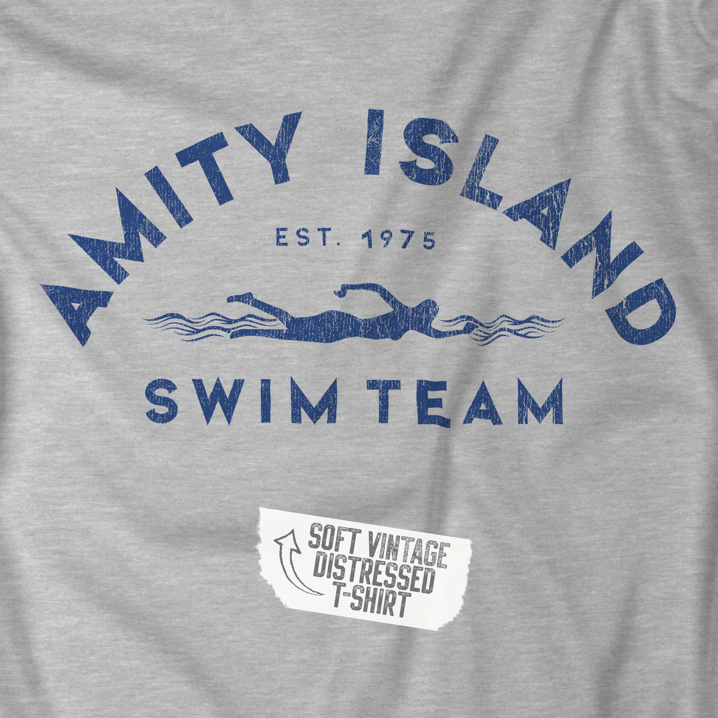 Closeup view of an Athletic Heather Grey colored Soft unisex Bella+Canvas 3001 short-sleeve t-shirt featuring an Amity Island Swim Team logo graphic, designed by ScriptedBrand, and inspired by the movie Jaws in a vintage distressed style.