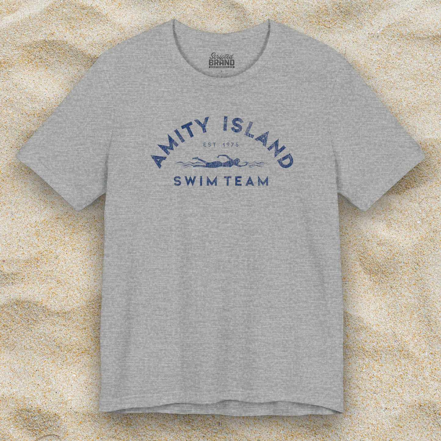 Front view of an Athletic Heather Grey colored Soft unisex Bella+Canvas 3001 short-sleeve t-shirt featuring an Amity Island Swim Team logo graphic, designed by ScriptedBrand, and inspired by the movie Jaws in a vintage distressed style.