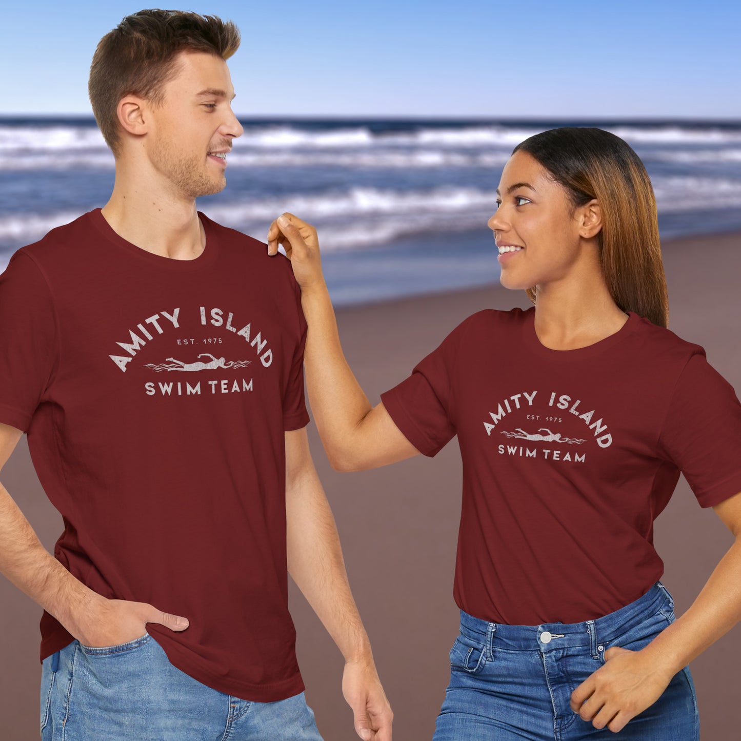 3 models wearing cardinal red lifeguard colored Soft unisex Bella+Canvas 3001 short-sleeve t-shirts featuring an Amity Island Swim Team logo graphic, designed by ScriptedBrand, and inspired by the movie Jaws in a vintage distressed style.