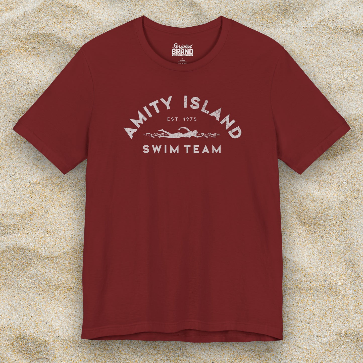 Front view of a cardinal red lifeguard colored Soft unisex Bella+Canvas 3001 short-sleeve t-shirt featuring an Amity Island Swim Team logo graphic, designed by ScriptedBrand, and inspired by the movie Jaws in a vintage distressed style.