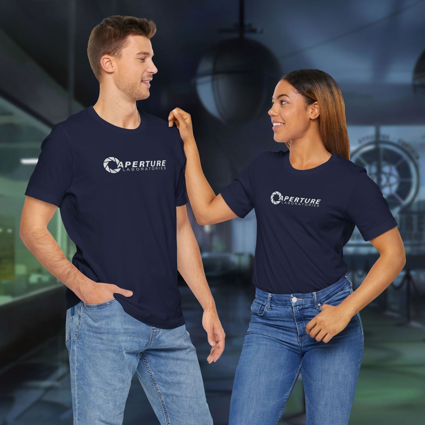 2 models wearing navy blue soft Bella+Canvas t-shirts with the Aperture Laboratories logo from the video game Portal and Portal 2 in a vintage ink-stamped distressed style.