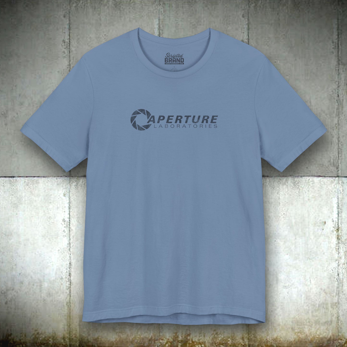 Steel blue colored soft Bella+Canvas t-shirt with the Aperture Laboratories logo from the video game Portal and Portal 2 in a vintage ink-stamped distressed style.