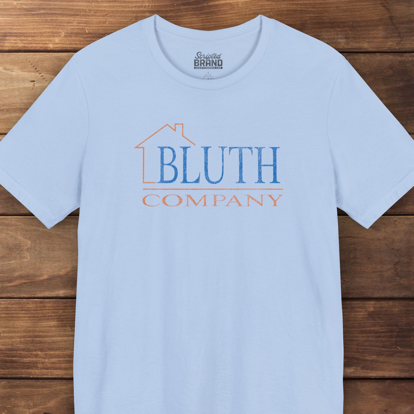 Front view of baby blue Bella+Canvas t-shirt featuring a vintage Bluth Company logo inspired by the TV show Arrested Development.