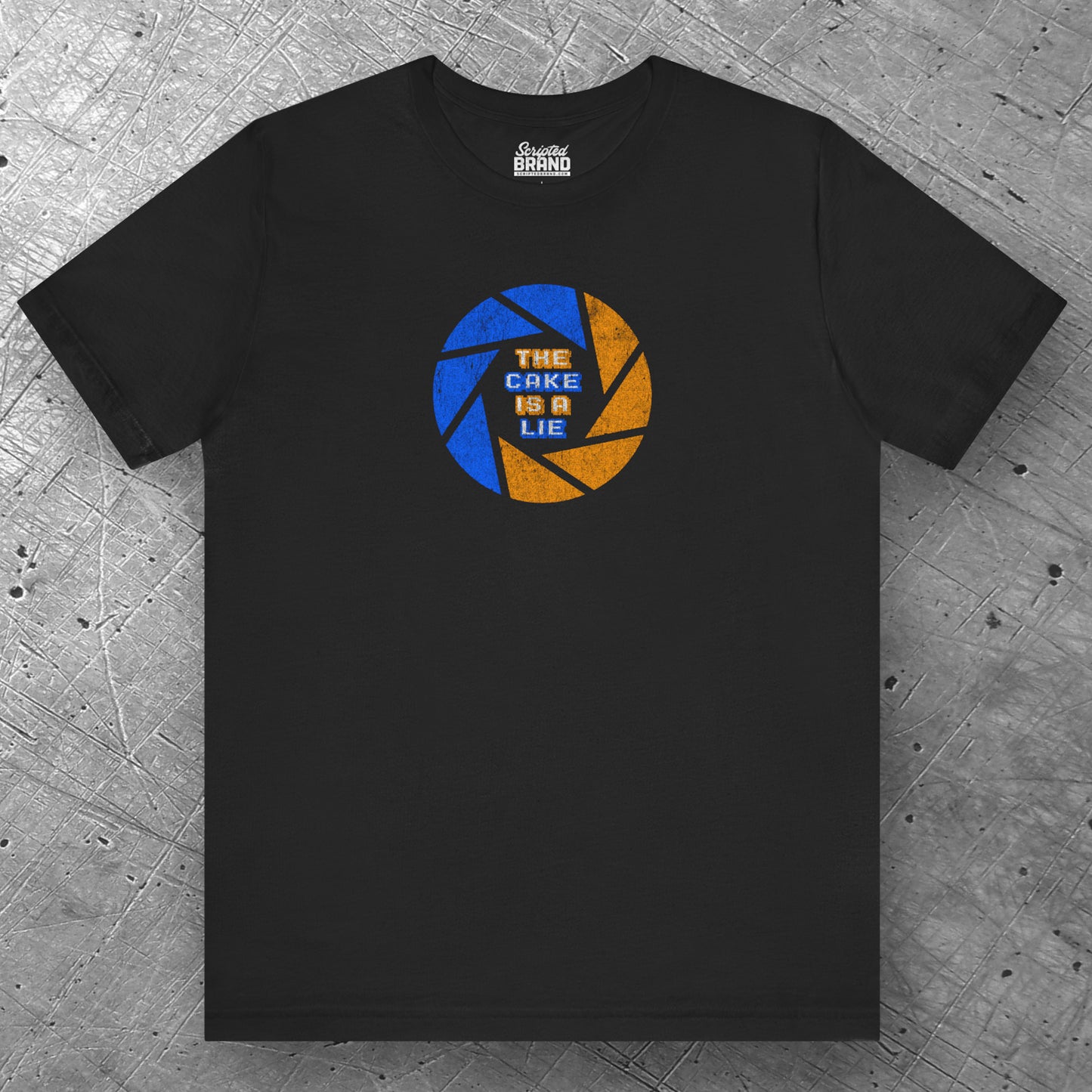 Front view of a black colored soft Bella+Canvas 3001 short-sleeve t-shirt featuring the phrase The Cake Is a Lie, along with the Aperture Laboratories shutter logo from the video game Portal and Portal 2 in a vintage distressed style, sold by ScriptedBrand.