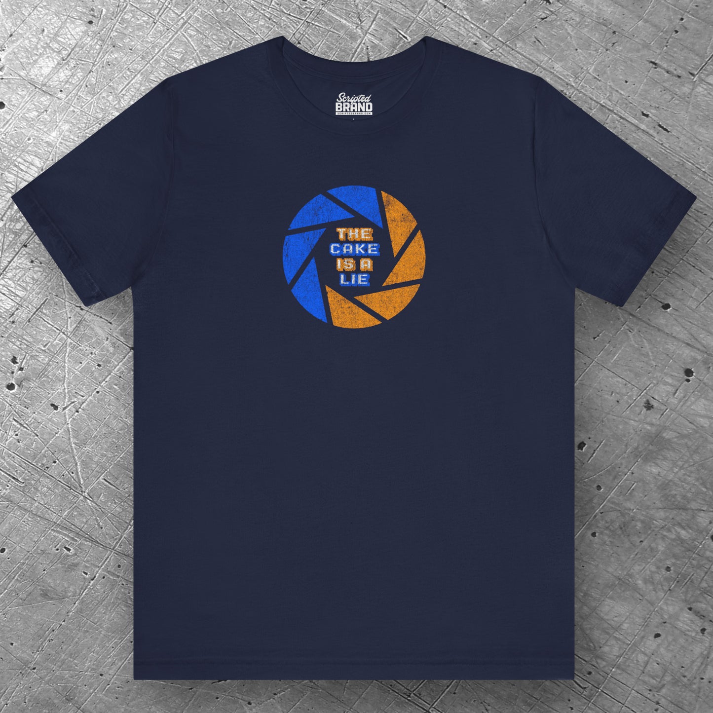 Front view of a navy blue colored soft Bella+Canvas 3001 short-sleeve t-shirt featuring the phrase The Cake Is a Lie, along with the Aperture Laboratories shutter logo from the video game Portal and Portal 2 in a vintage distressed style, sold by ScriptedBrand.