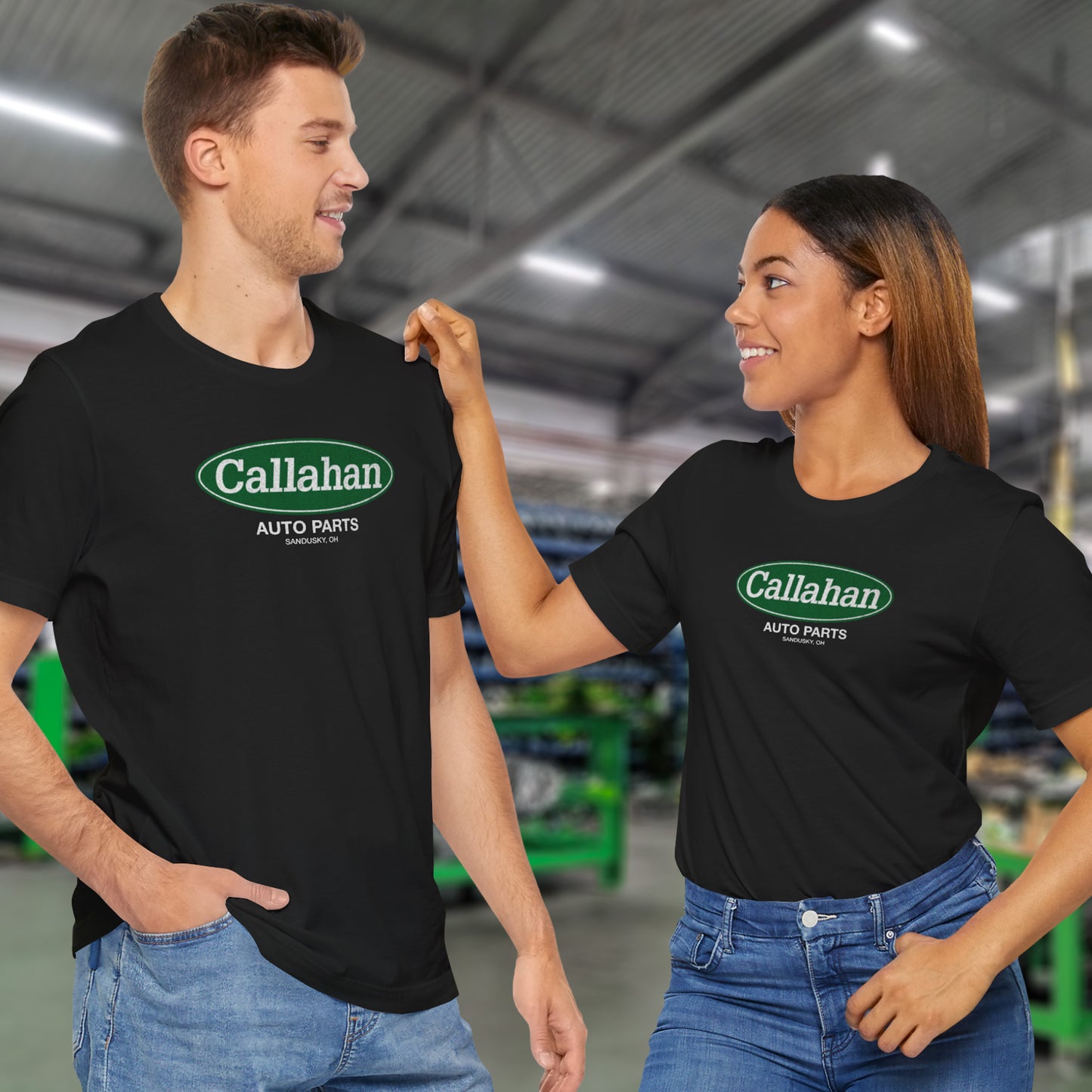 2 models wearing black soft short-sleeve t-shirts with the Callahan Auto Parts logo from the movie Tommy Boy in a vintage distressed style.