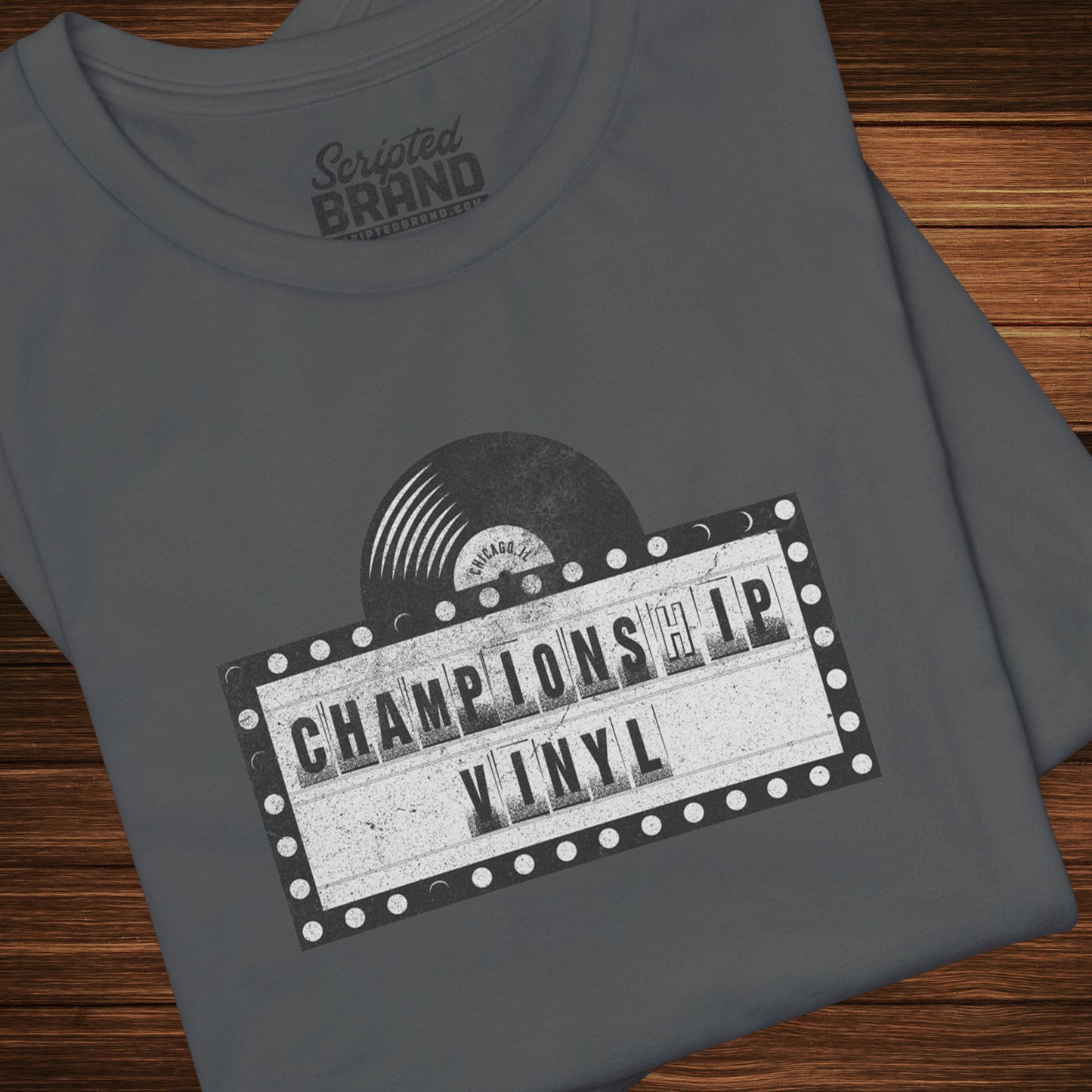 Folded Asphalt Gray t-shirt featuring the fictional logo CHAMPIONSHIP VINYL record store from movie High Fidelity in a vintage distressed style.