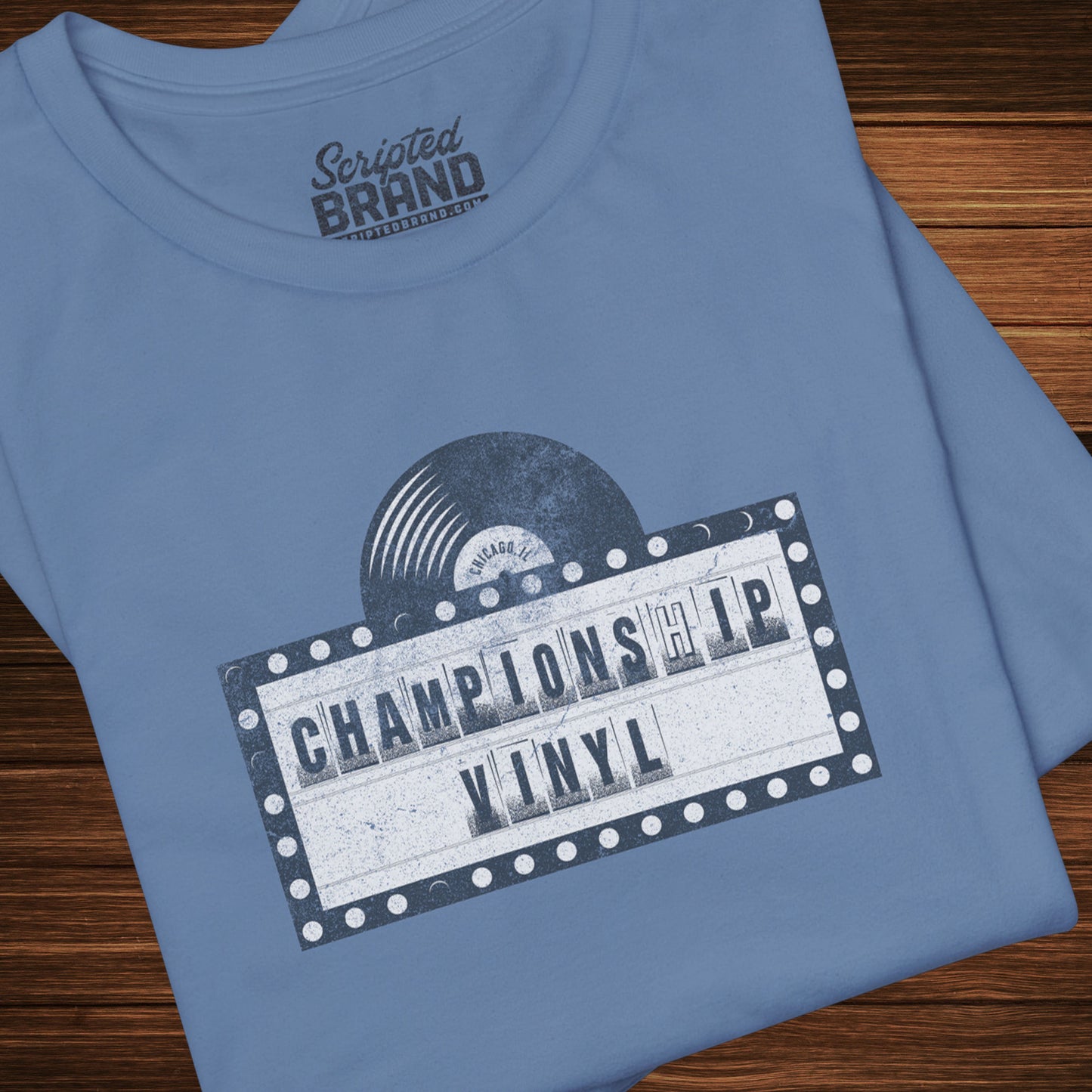 Folded Blue t-shirt featuring the fictional logo CHAMPIONSHIP VINYL record store from movie High Fidelity in a vintage distressed style.