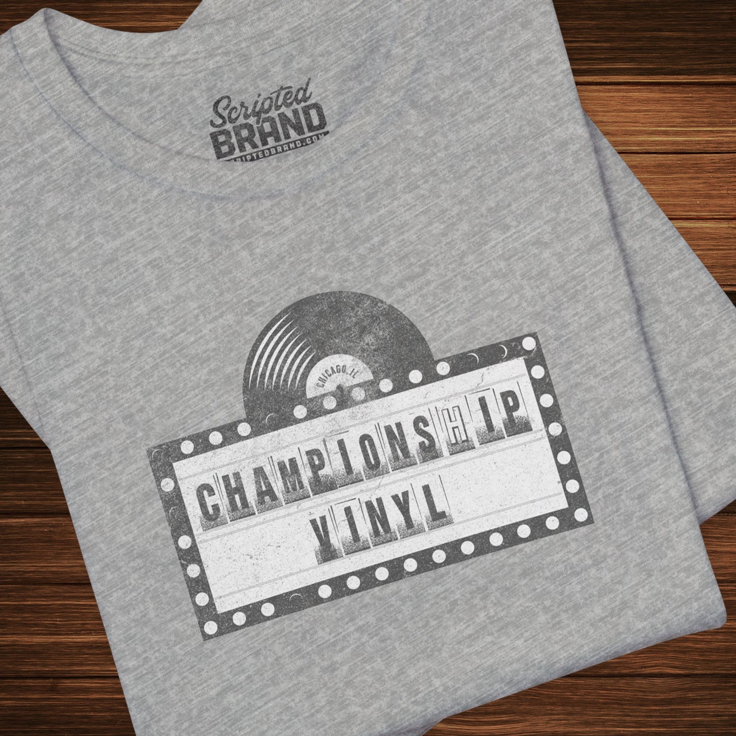 Folded Heather Gray t-shirt featuring the fictional logo CHAMPIONSHIP VINYL record store from movie High Fidelity in a vintage distressed style.