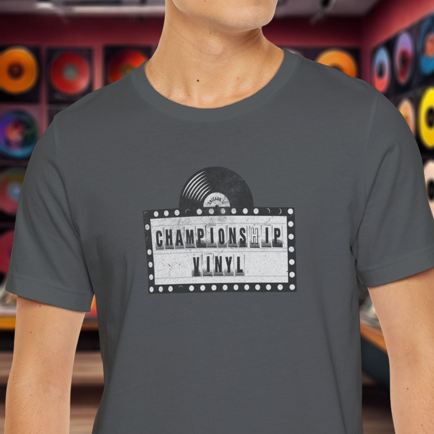 Male wearing Asphalt Gray t-shirt featuring the fictional logo CHAMPIONSHIP VINYL record store from movie High Fidelity in a vintage distressed style.