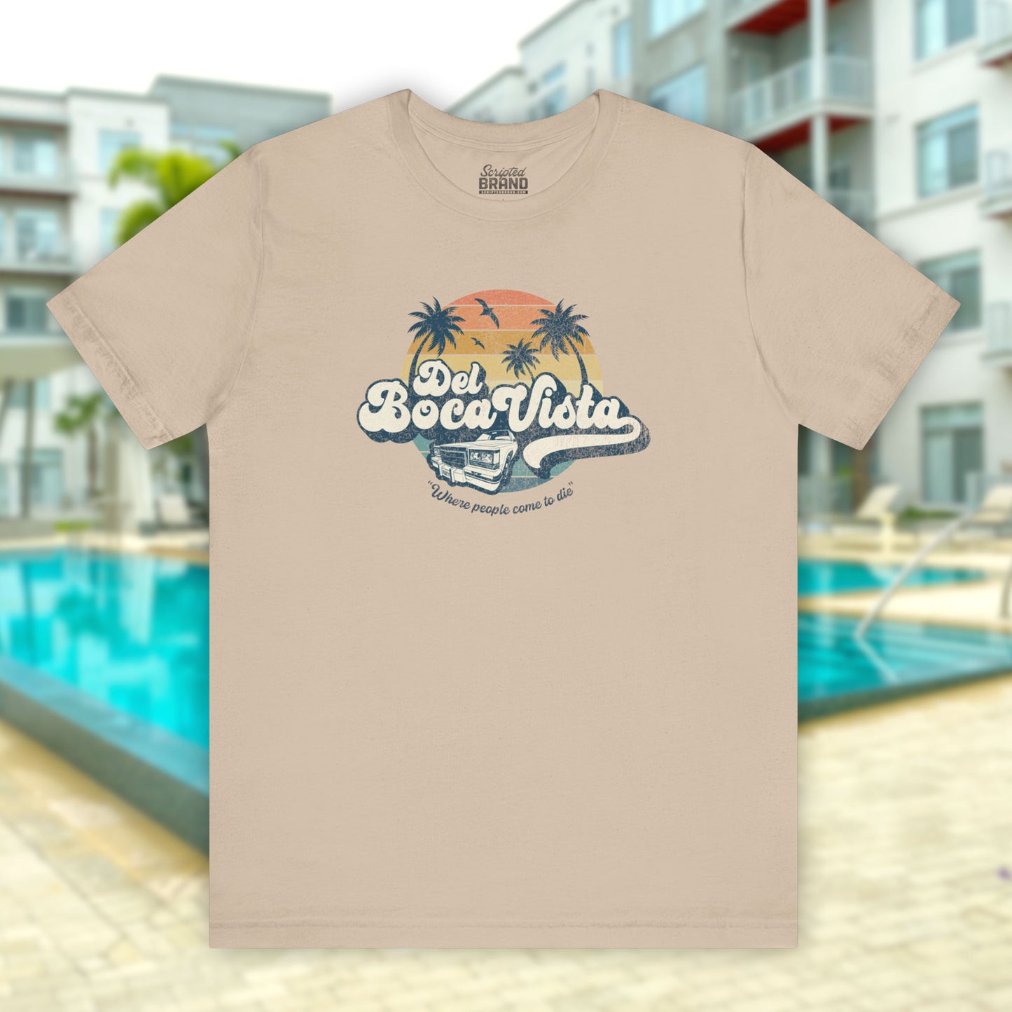 Front view of a tan Soft Bella+Canvas 3001 short-sleeve t-shirt featuring a Del Boca Vista logo graphic (uniquely designed by ScriptedBrand), including the phrase Where People Come To Die, inspired by the TV show Seinfeld, in a vintage distressed style.