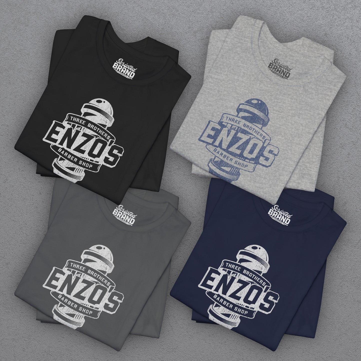 Group of 4 folded soft unisex Bella+Canvas 3001 short-sleeve t-shirts featuring a unique Enzo's Barber Shop logo graphic, designed by ScriptedBrand in a vintage distressed style, and inspired by the TV show Seinfeld.