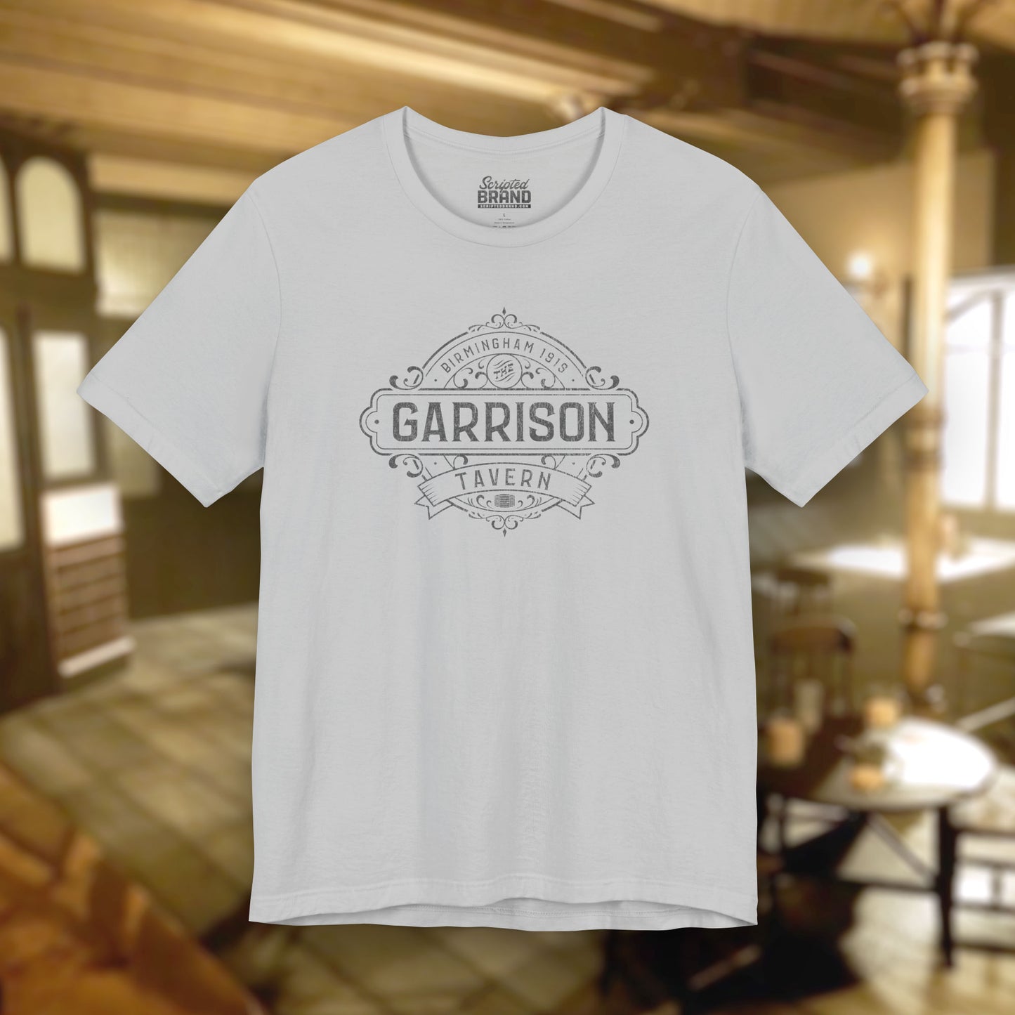 Front view of a solid athletic gray soft Bella+Canvas 3001 short-sleeve t-shirt featuring the Garrison Tavern Bar Logo Graphic inspired by the TV show and movie Peaky Blinders in a vintage distressed style, sold by ScriptedBrand.