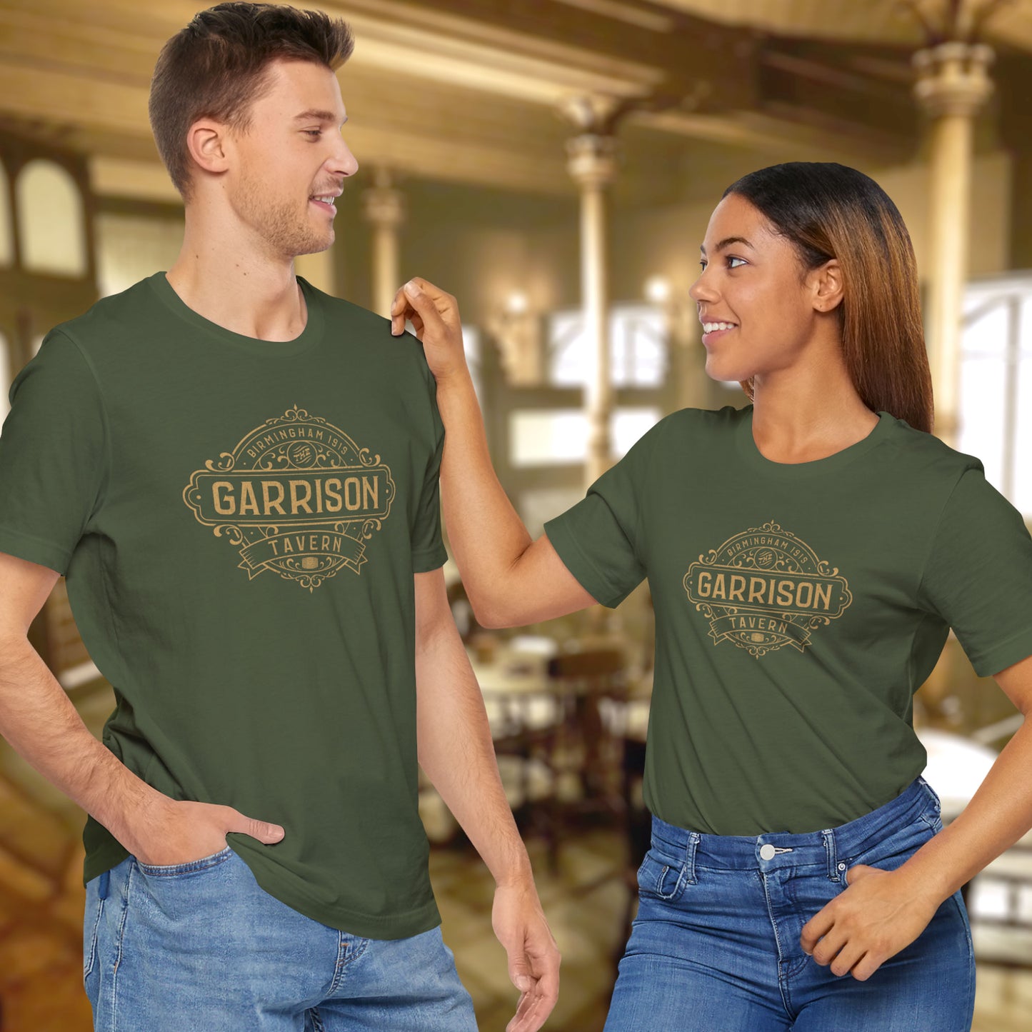 2 models wearing military green soft Bella+Canvas 3001 short-sleeve t-shirts featuring the Garrison Tavern Bar Logo Graphic inspired by the TV show and movie Peaky Blinders in a vintage distressed style, sold by ScriptedBrand.